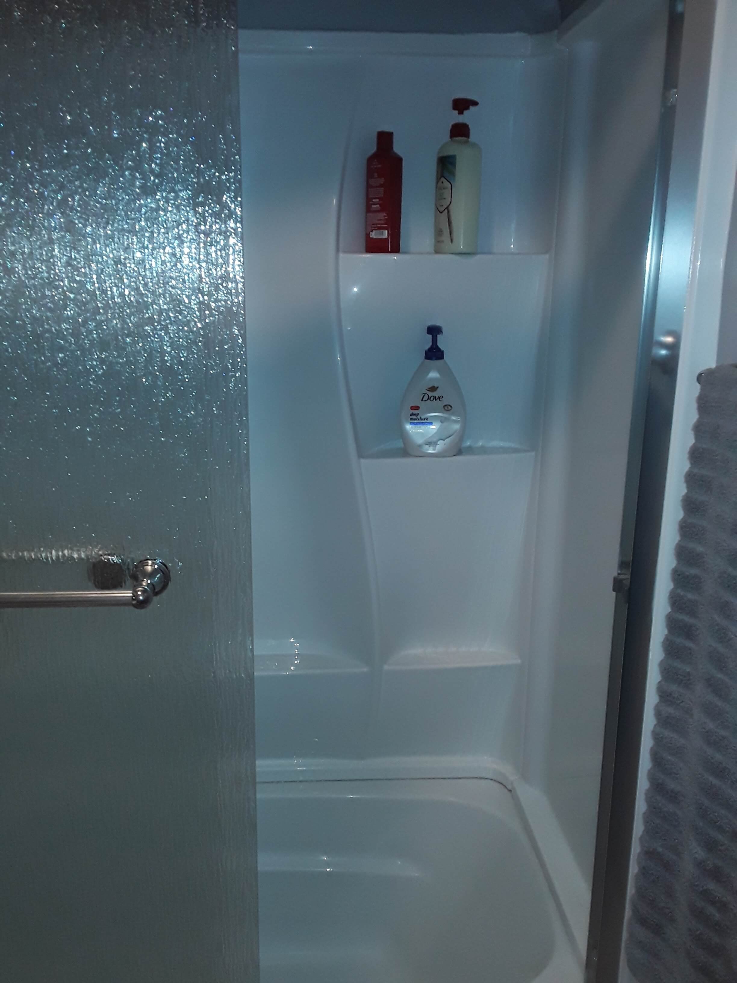 Shower and tub combination with frosted sliding glass enclosure in renovated bathroom