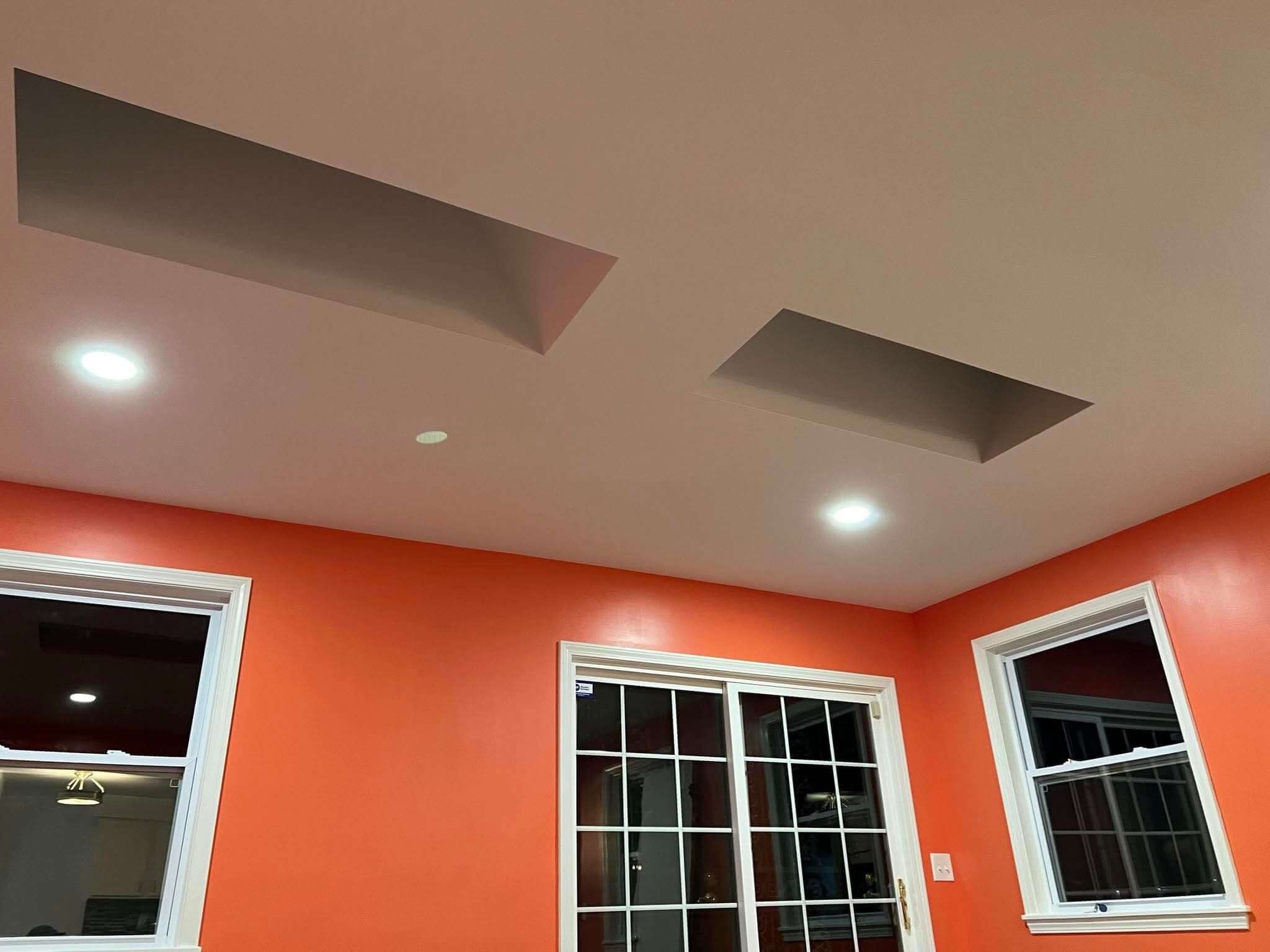 Close-up of a home addition ceiling showing custom recessed skylight wells with modern energy-efficient recessed lighting against a clean drywall finish, by DLR Construction