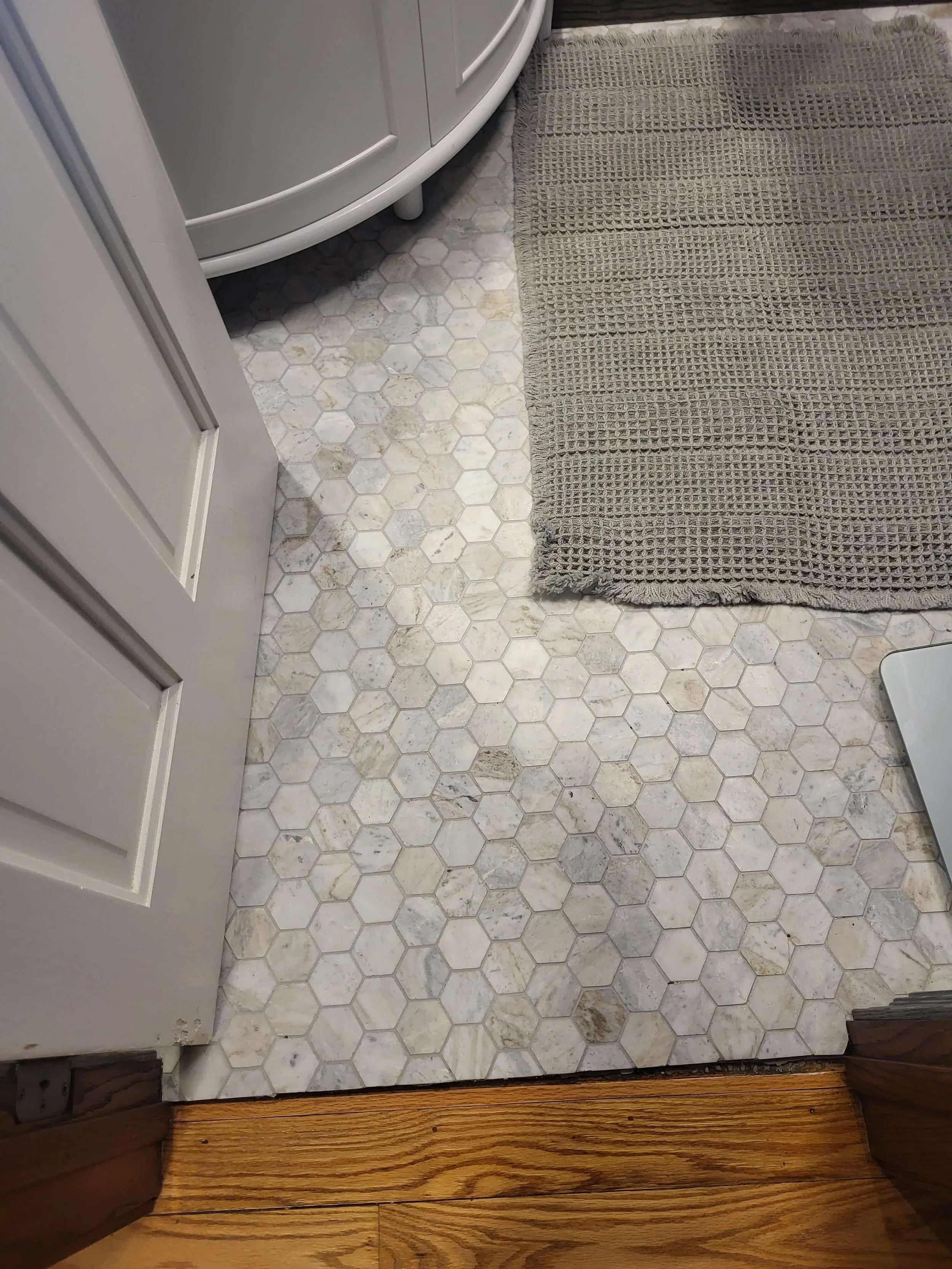 Bathroom remodel in Northeast Ohio with hexagon tile flooring and dark trim detail