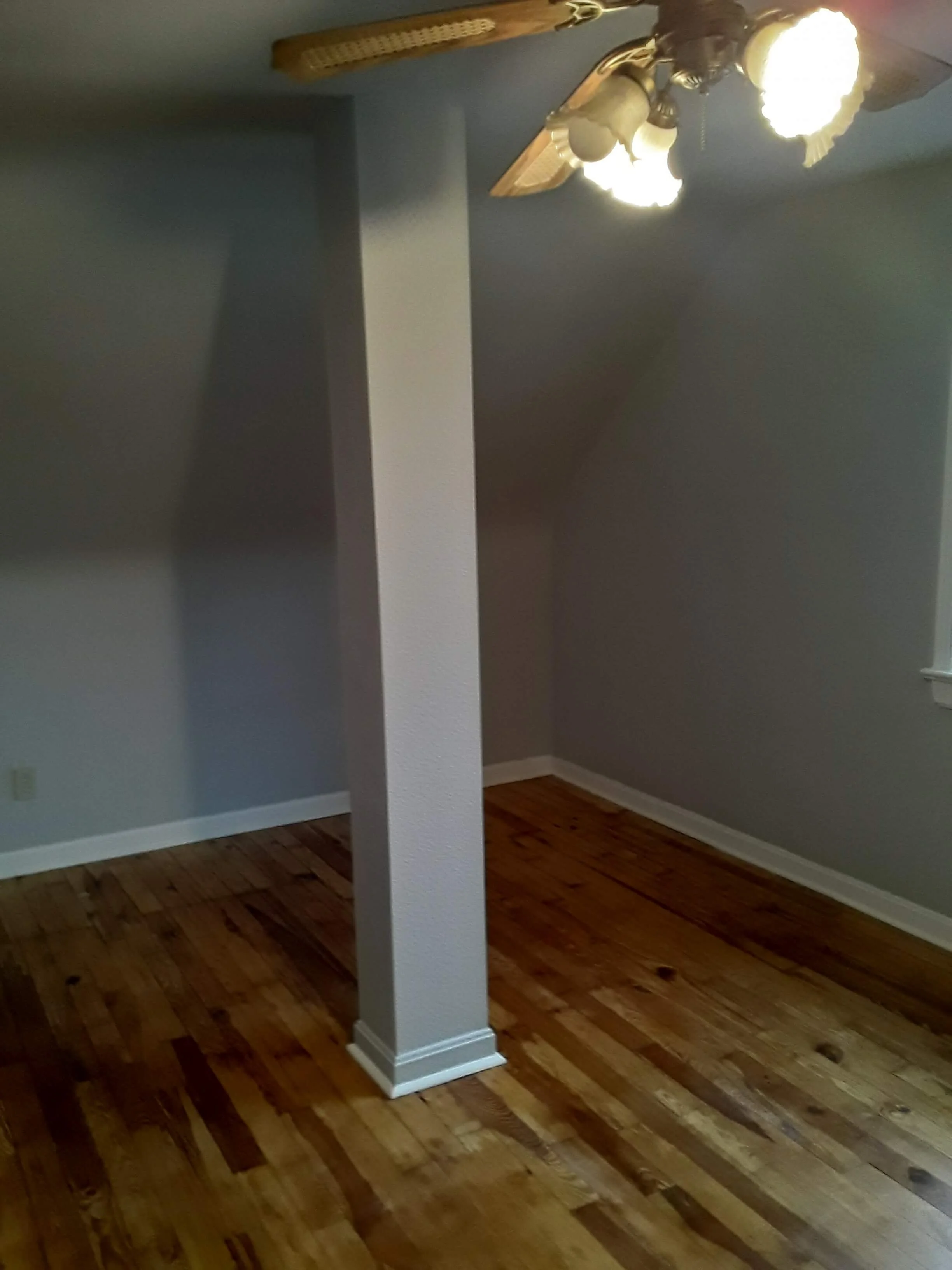 Structural interior corner detailing showcasing newly finished hardwood surfaces and custom finish carpentry wrap work around a home pillar by DLR Construction in Cleveland, Ohio.