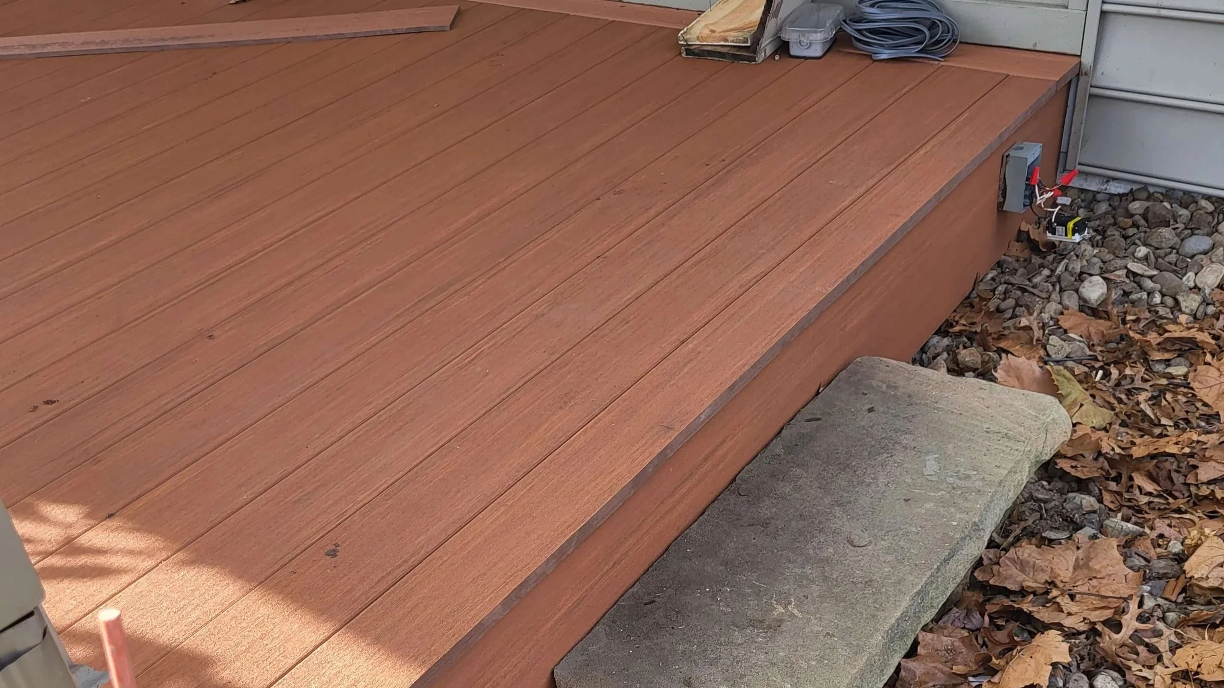 Electrical box detail installed on composite front porch decking