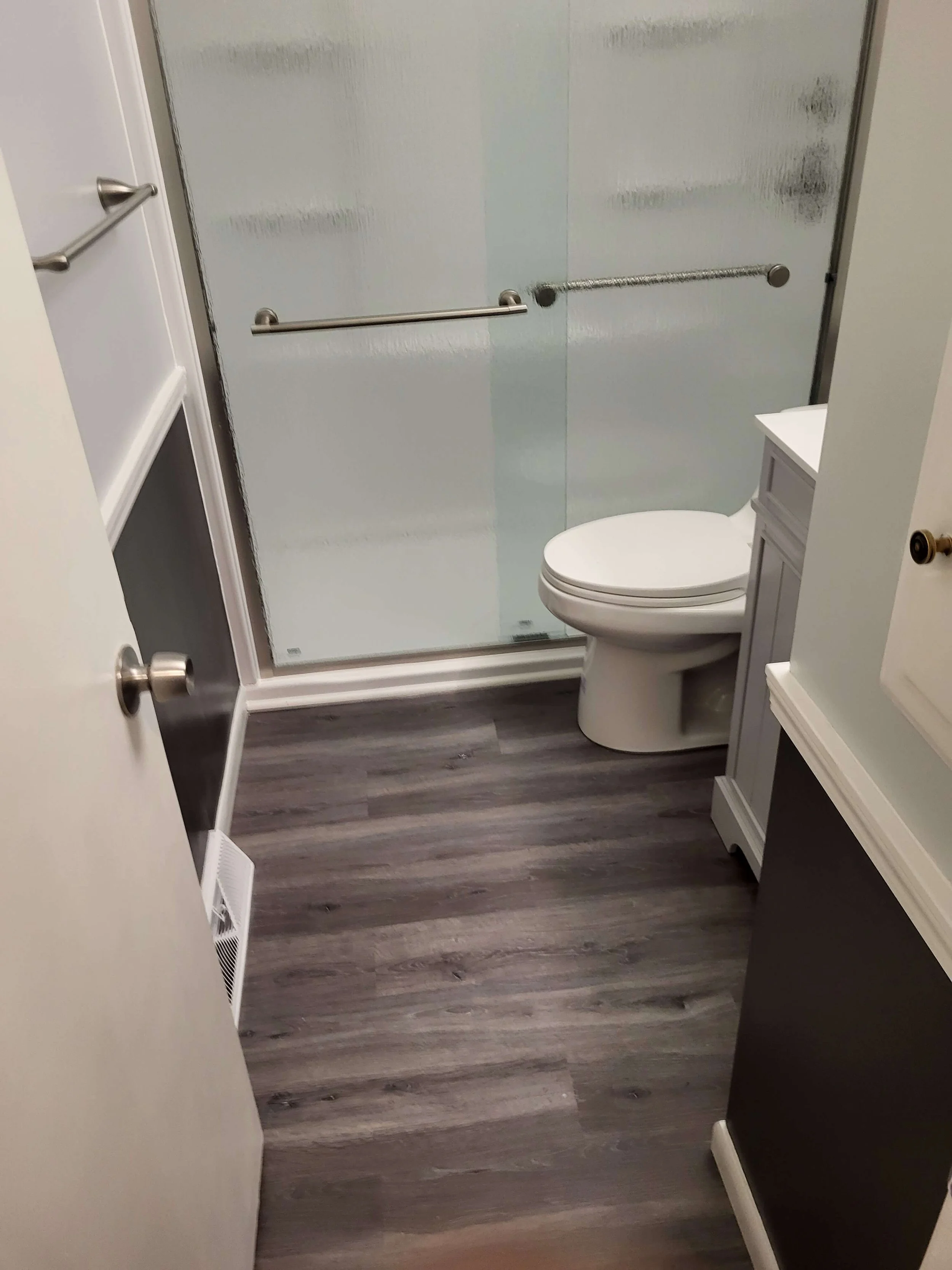 Modern bathroom remodel with sliding glass doors and vinyl flooring by DLR Construction in Medina, Ohio.