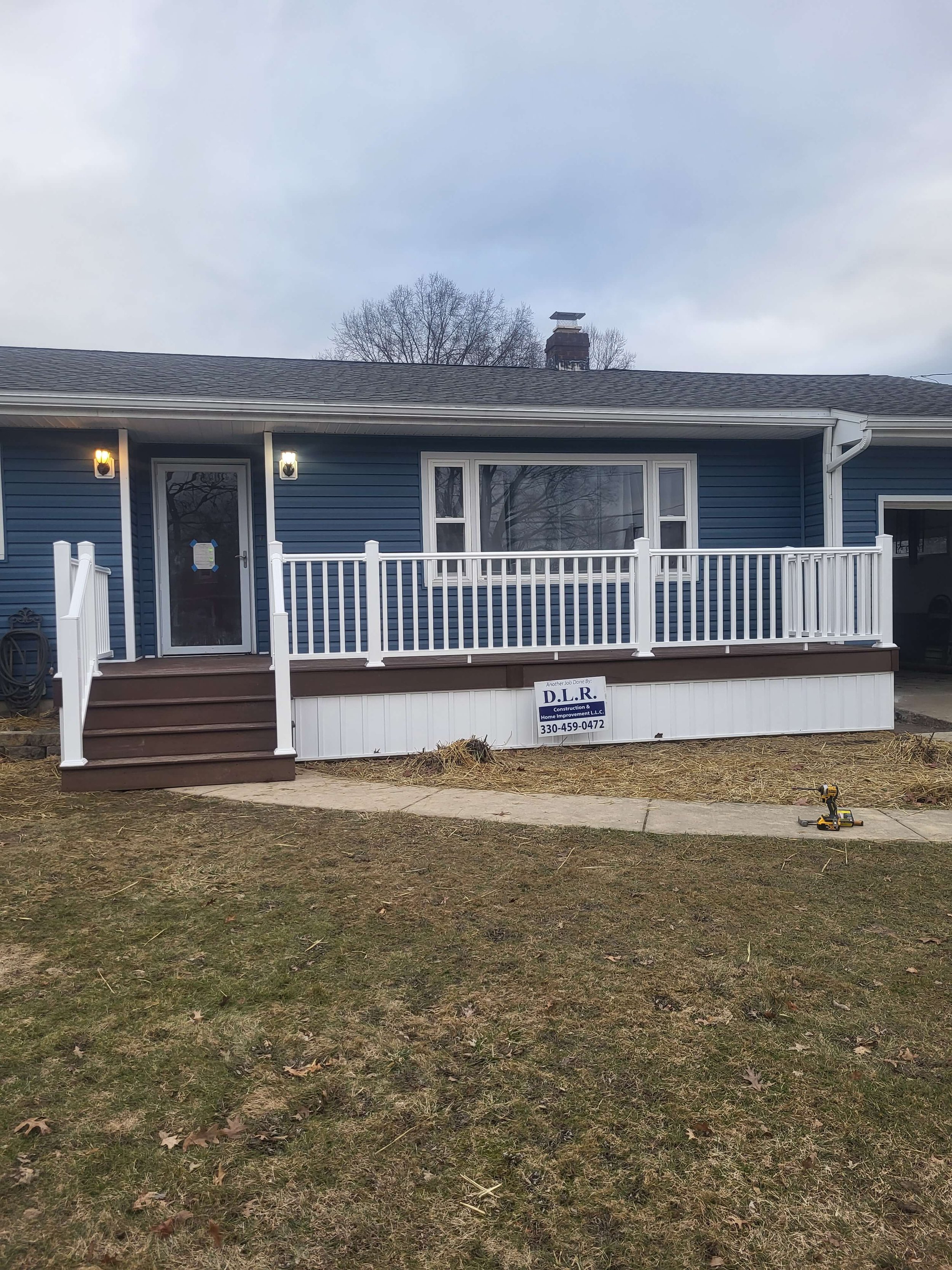 Front exterior custom deck replacement with new railings and steps on a Northeast Ohio home.