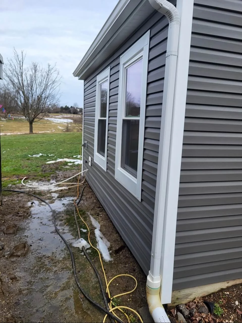 Modern gray vinyl siding installation paired with brand new white vinyl replacement windows on a house in Medina Ohio