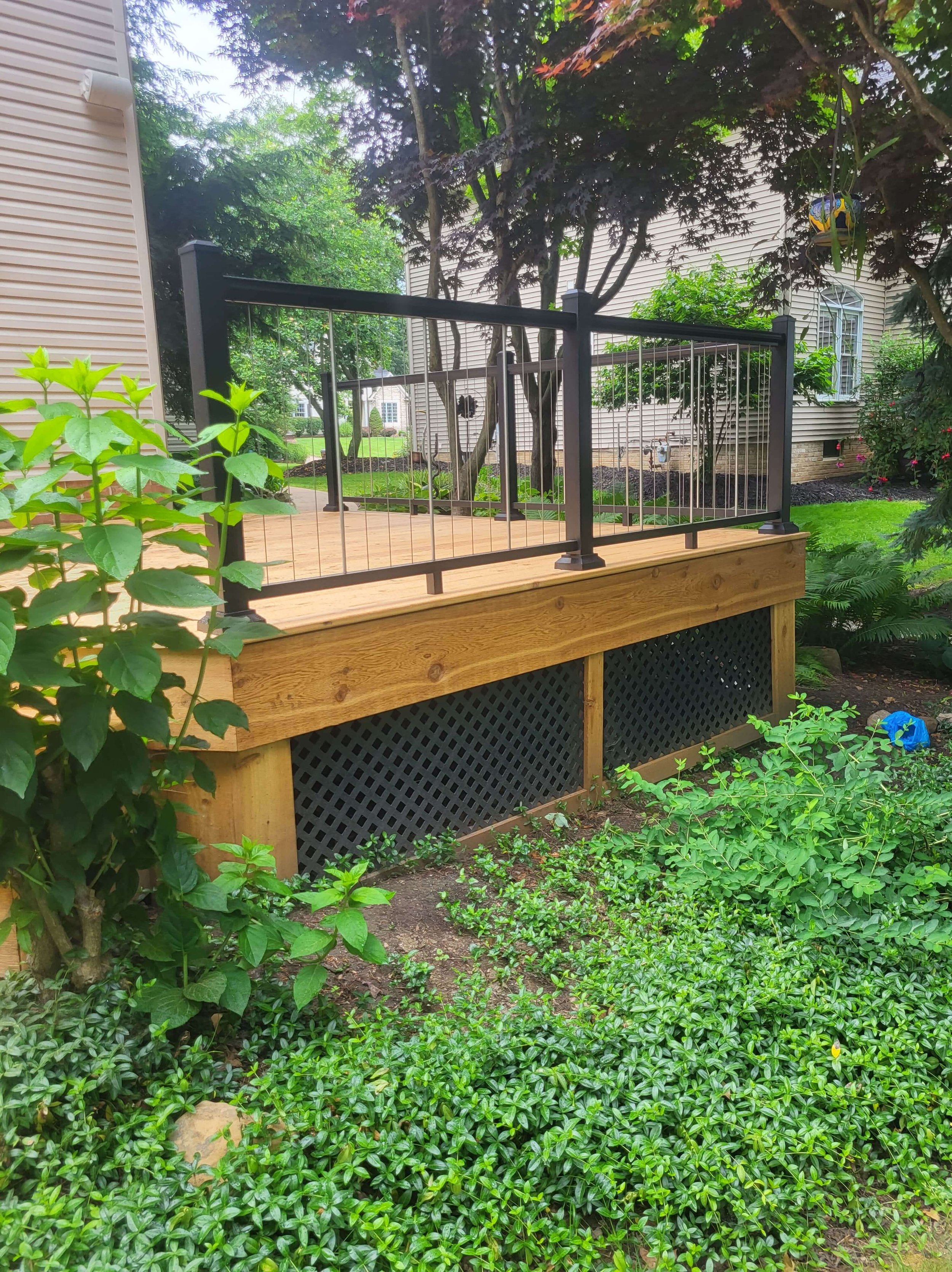 Finished cedar deck with railing and skirting shown from a wide angle highlighting overall design and craftsmanship