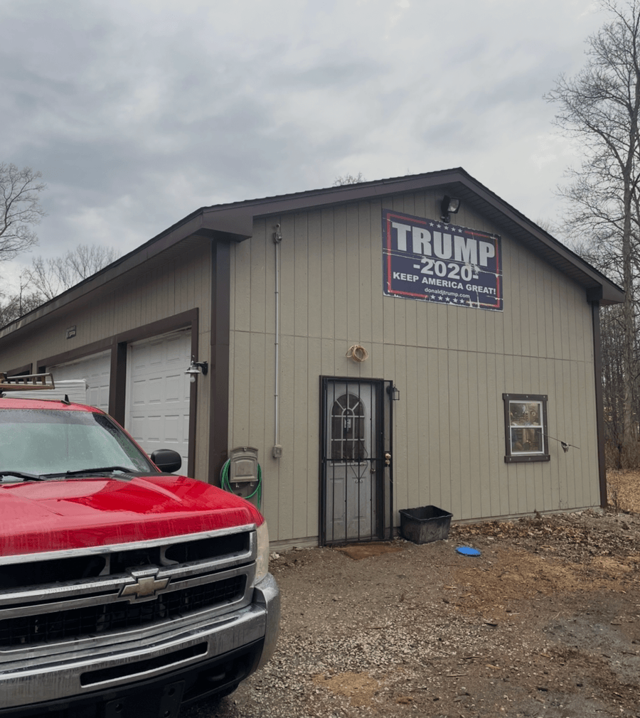 Completed detached garage and pole barn construction project in Stow, Ohio with gray metal siding, white trim, and a red pickup truck parked out front by DLR Construction.