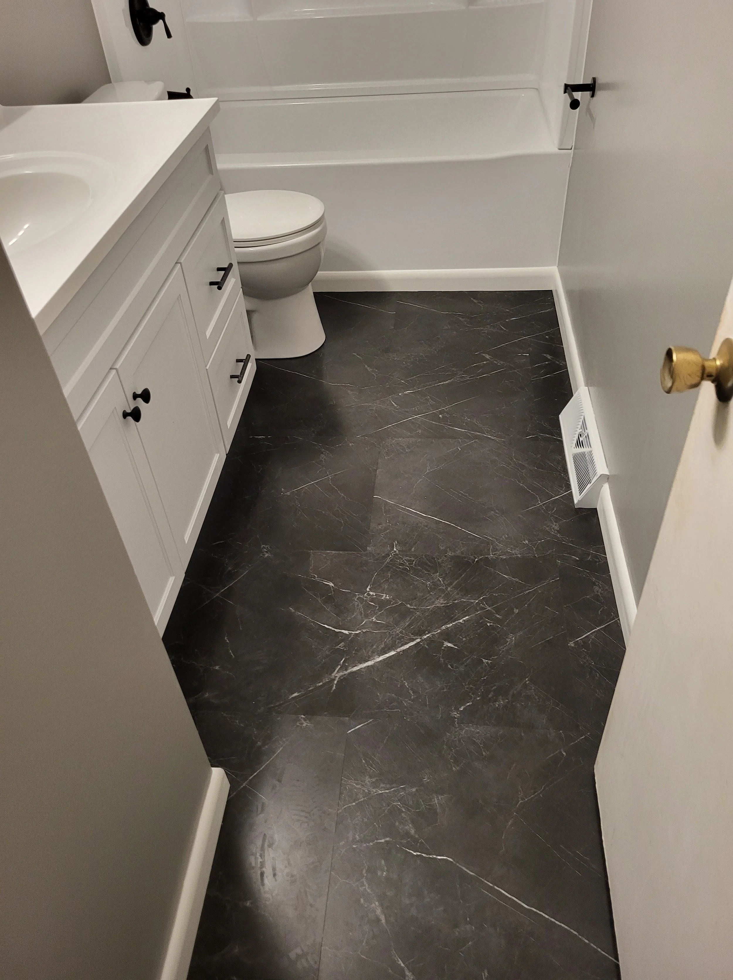 Large-Format-Tile with Vinyl Trim around the tub and New Register cover