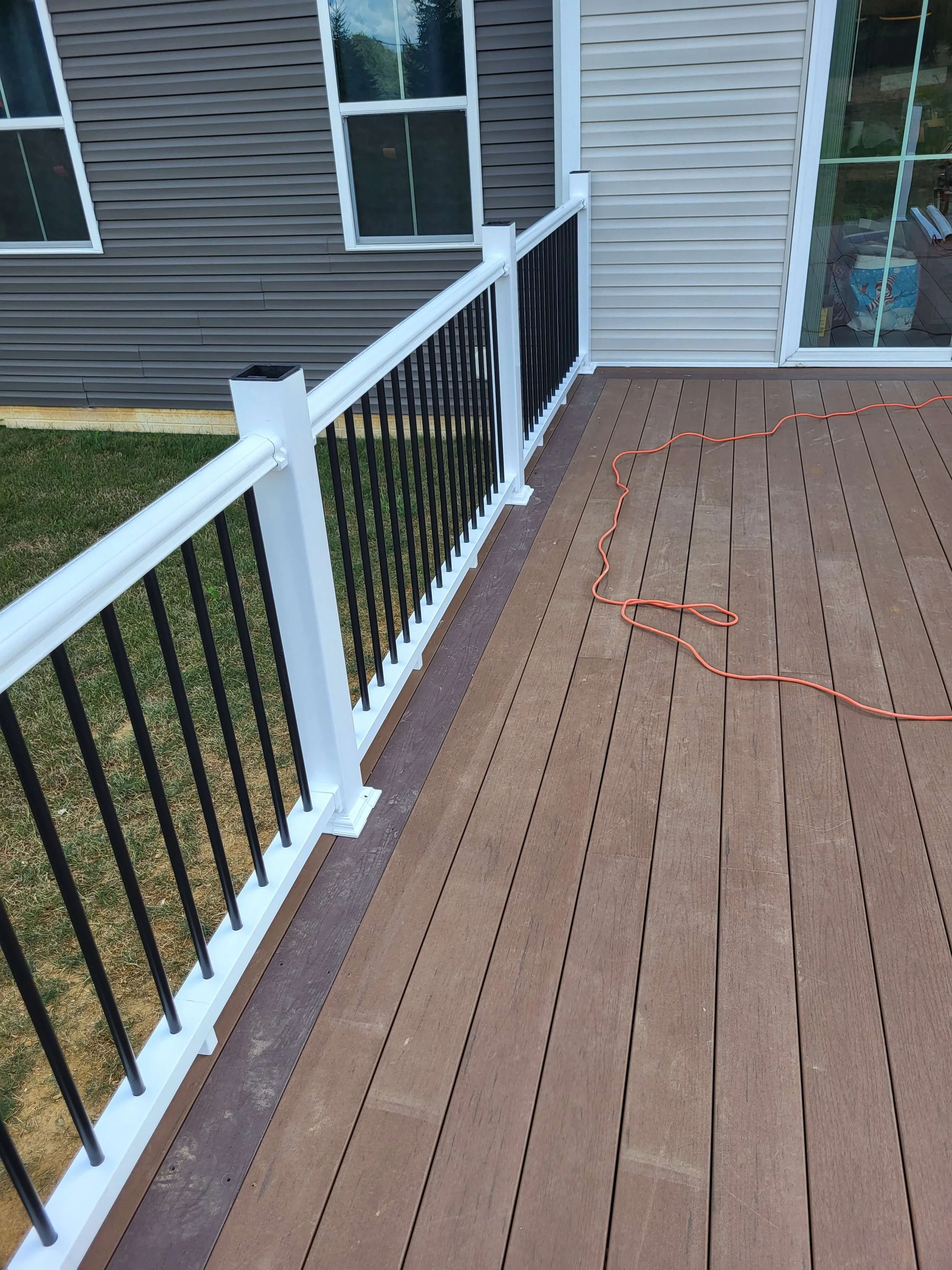 White vinyl deck railing with black aluminum balusters providing modern contrast