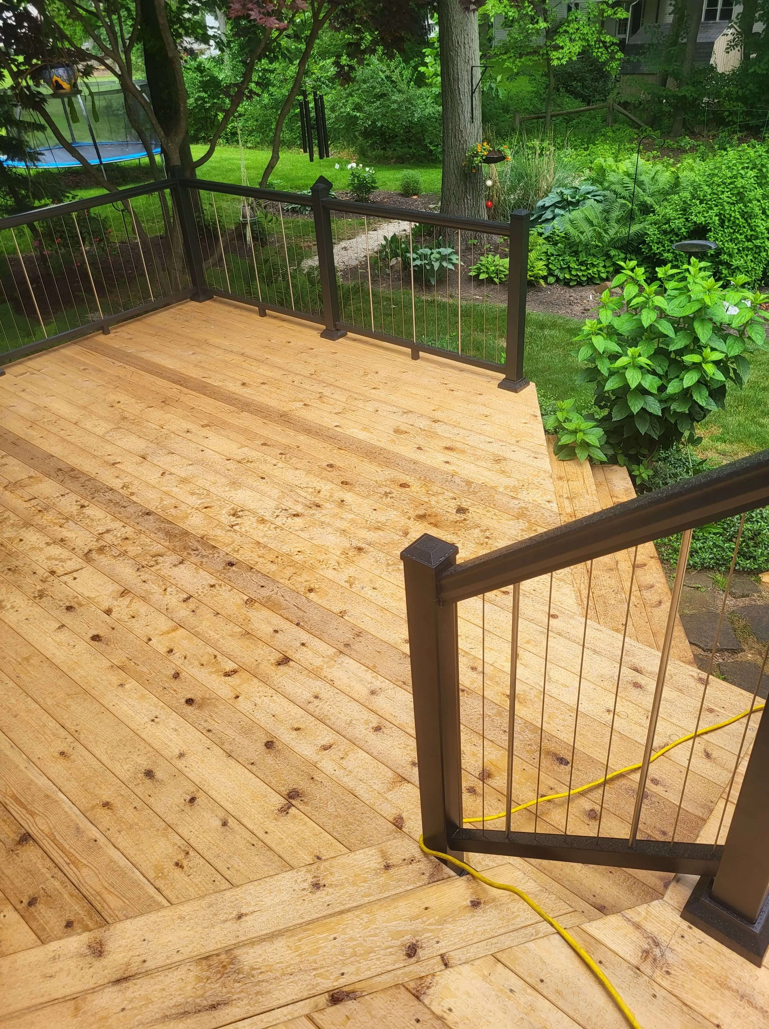 Cedar deck layout showing transition toward railing and step area with balanced design and spacing