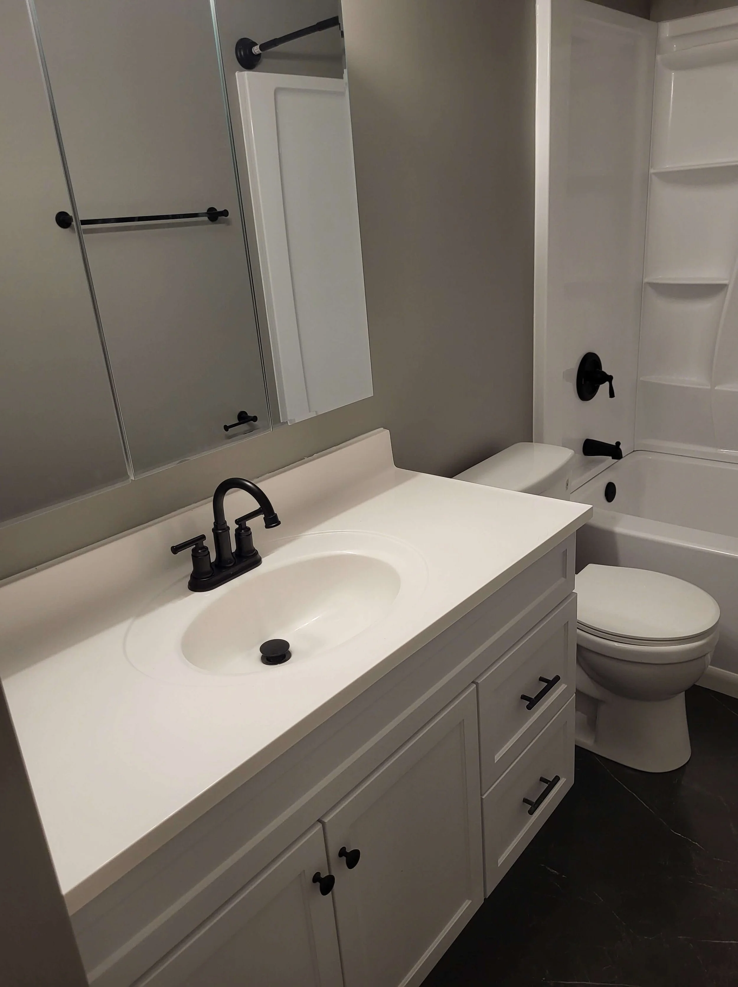 DLR Construction home improvement craftsmanship highlighting a custom white vanity installation with an integrated sink and modern black fixtures