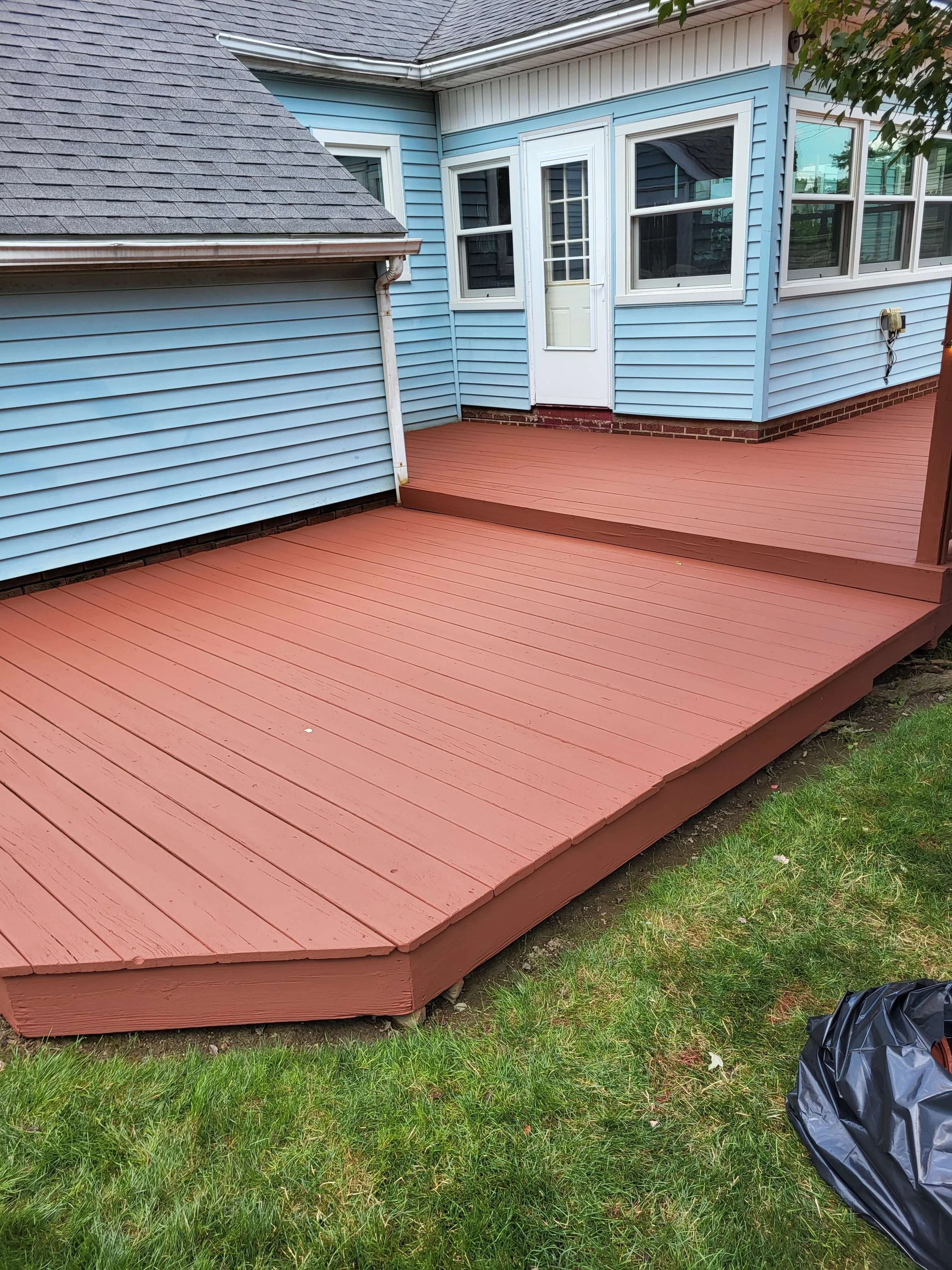A completely finished and painted backyard wood deck with a matching pergola structure built by DLR Construction.