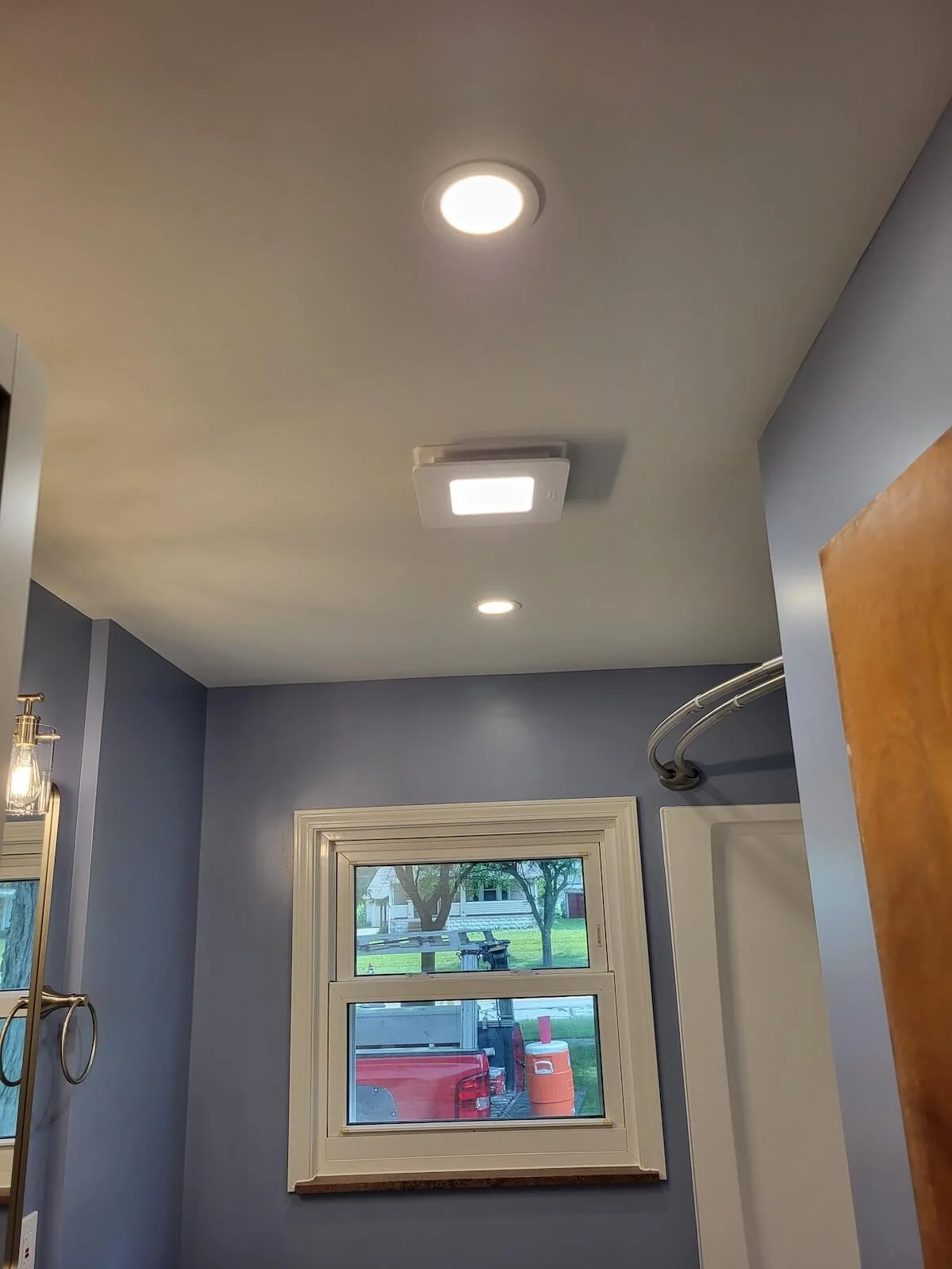 New window installation with a custom dark finish wood sill plate matching a modern bathroom remodel.