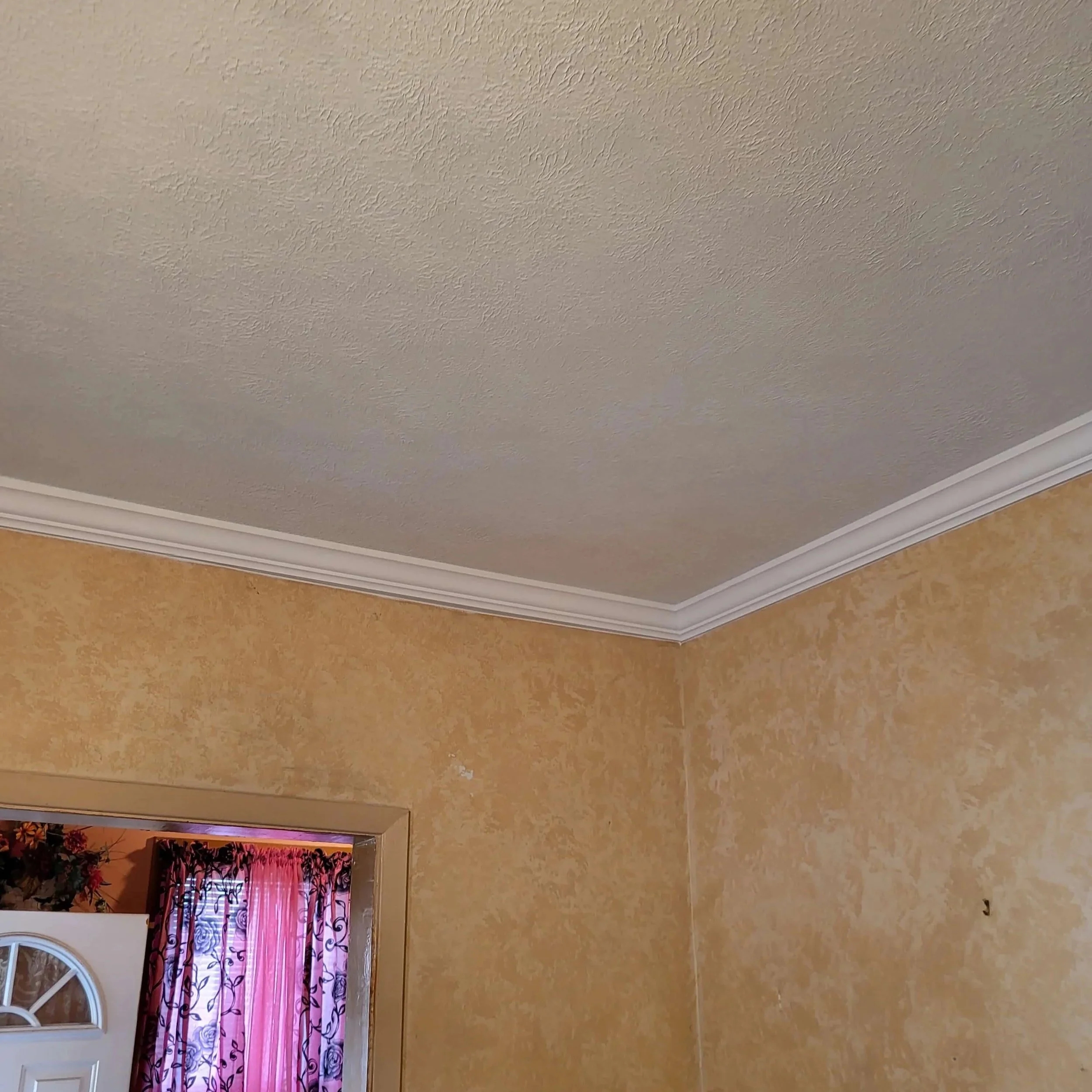 Another angle of a fully repaired and refinished living room ceiling after water damage from an upstairs toilet leak.
