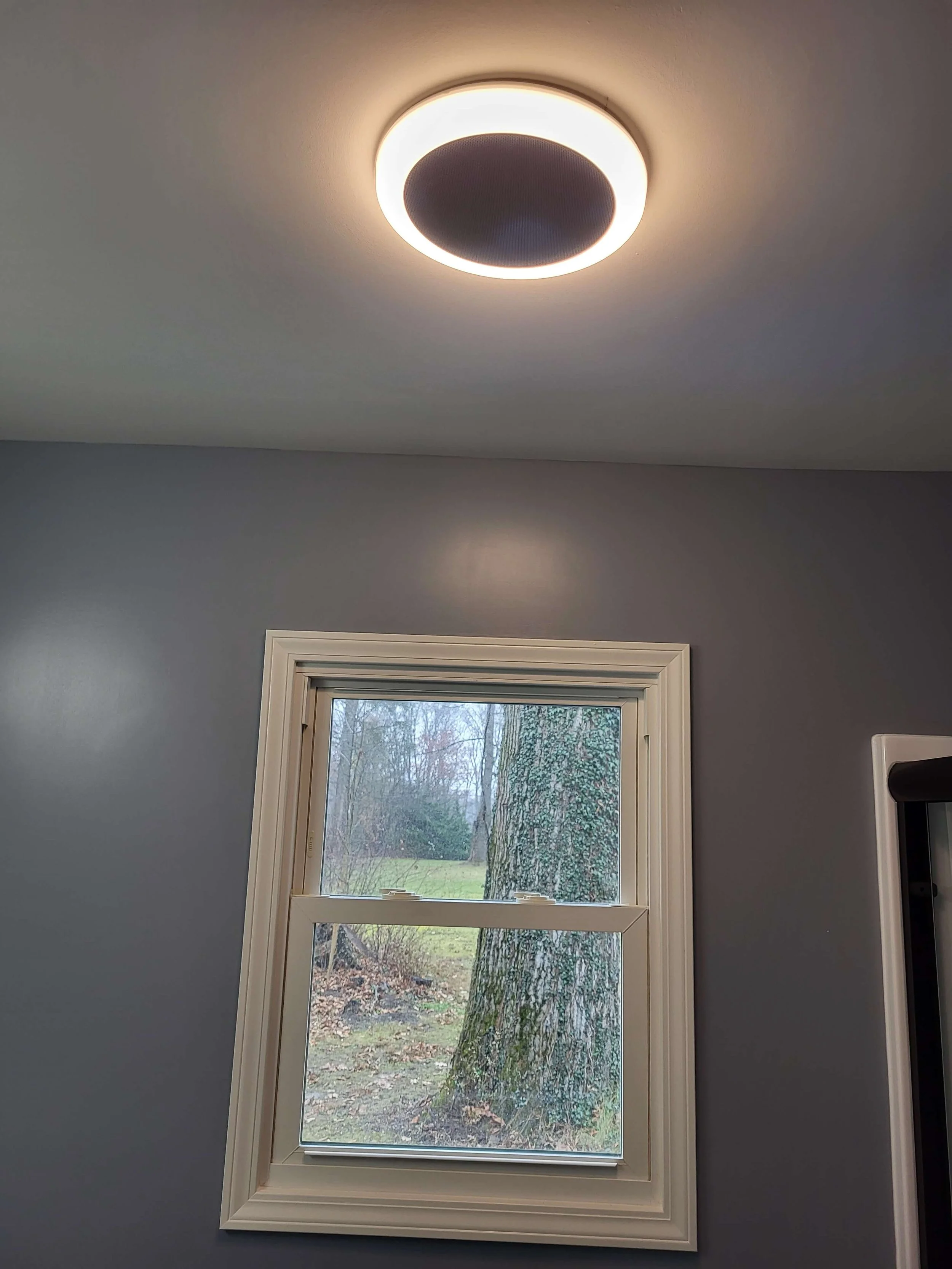 New bathroom window installation with modern ceiling ventilation light fixture and trim work.