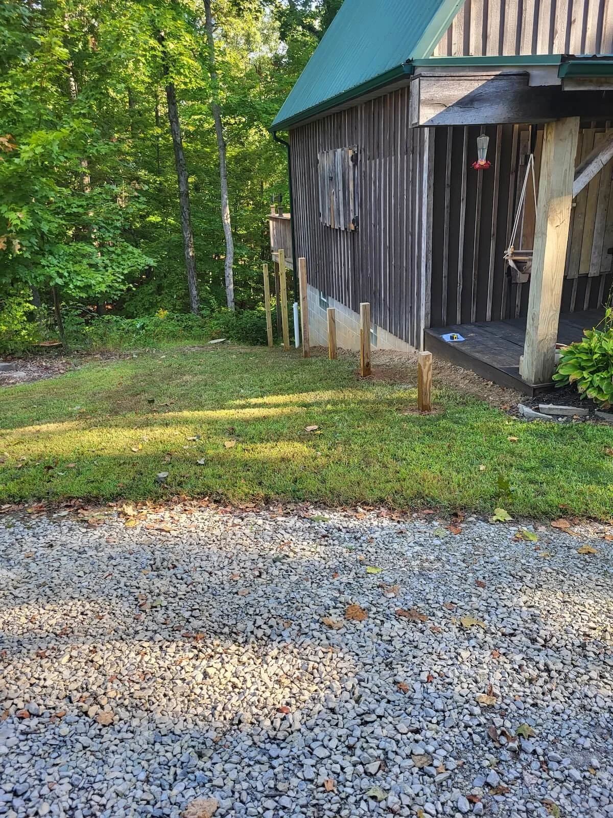 Under-construction view of custom timber post framing and excavation on a steep backyard hillside grade in Kent, Ohio.