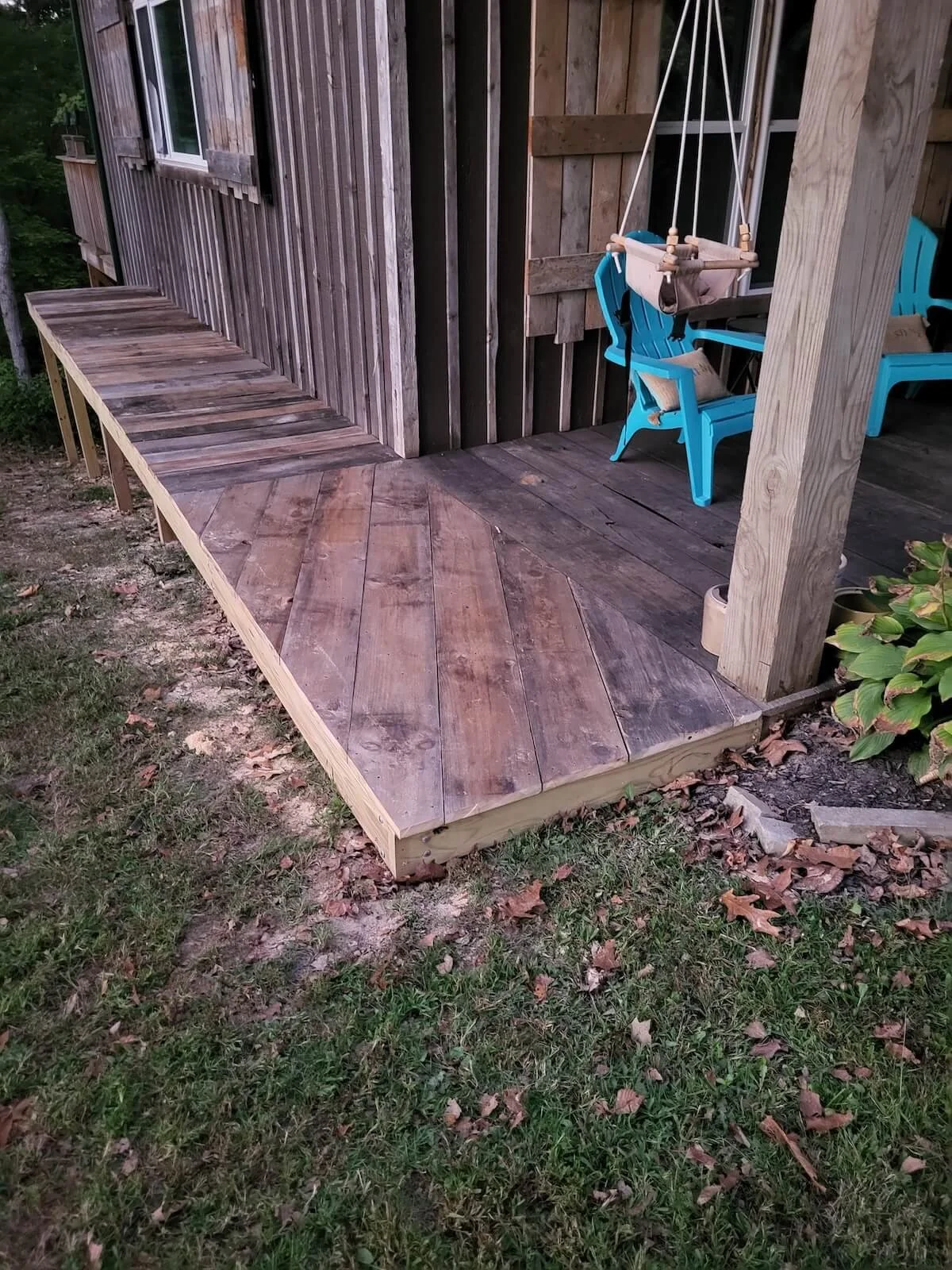 Finished treated deck boards showcasing a rich, dark custom oil weatherproofing finish on a cabin walkway.