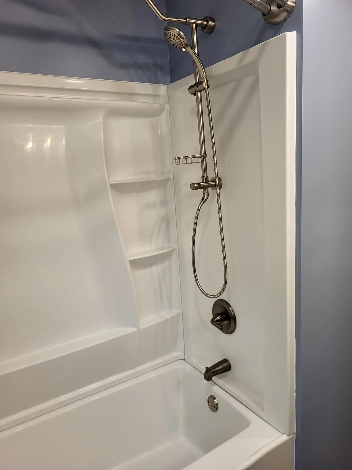 New clean white Delta shower and tub setup with high-end dual chrome fixtures.