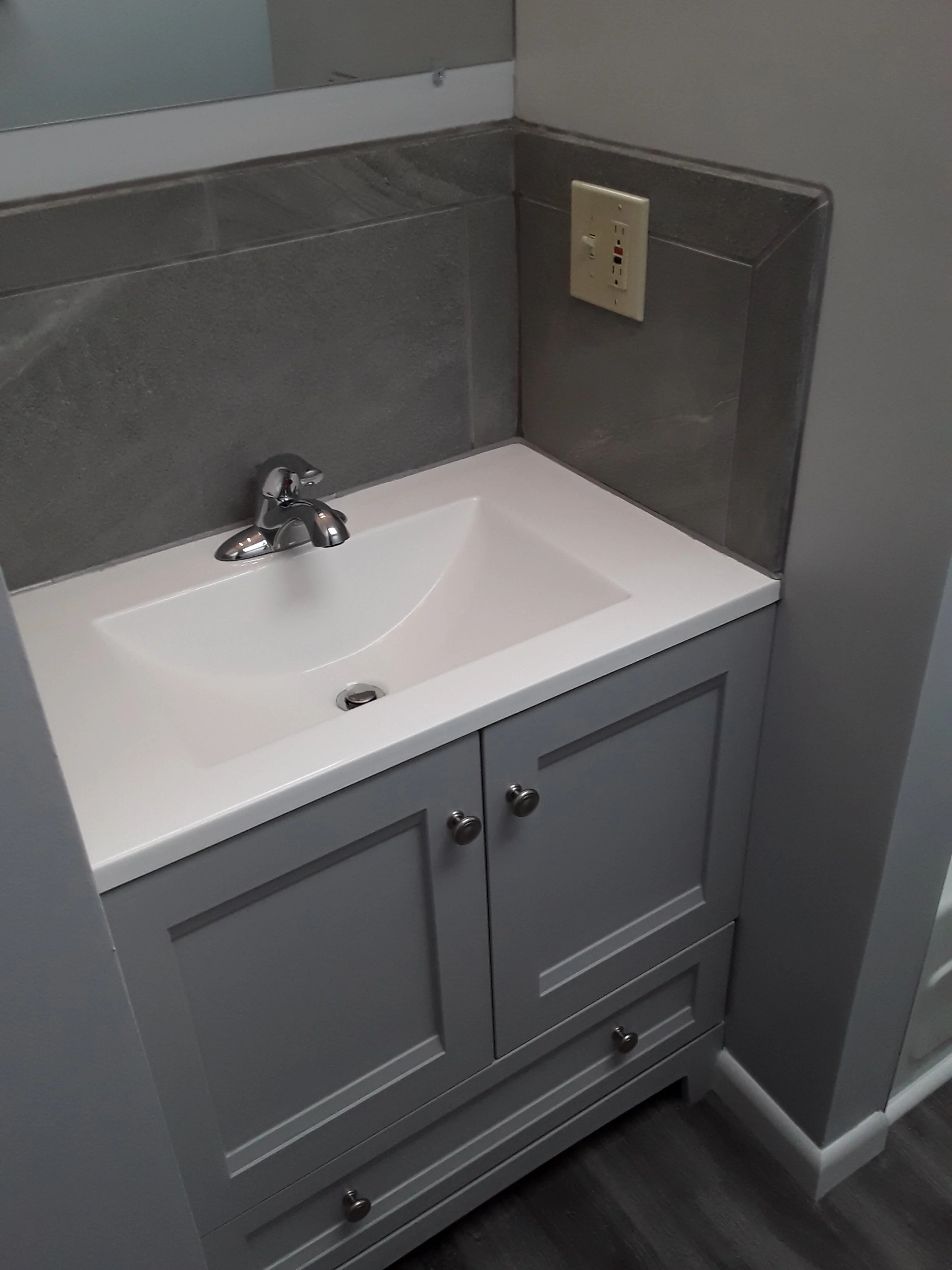 installed vanity with matching faucet and accessories, highlighting sleek design and functional storage.