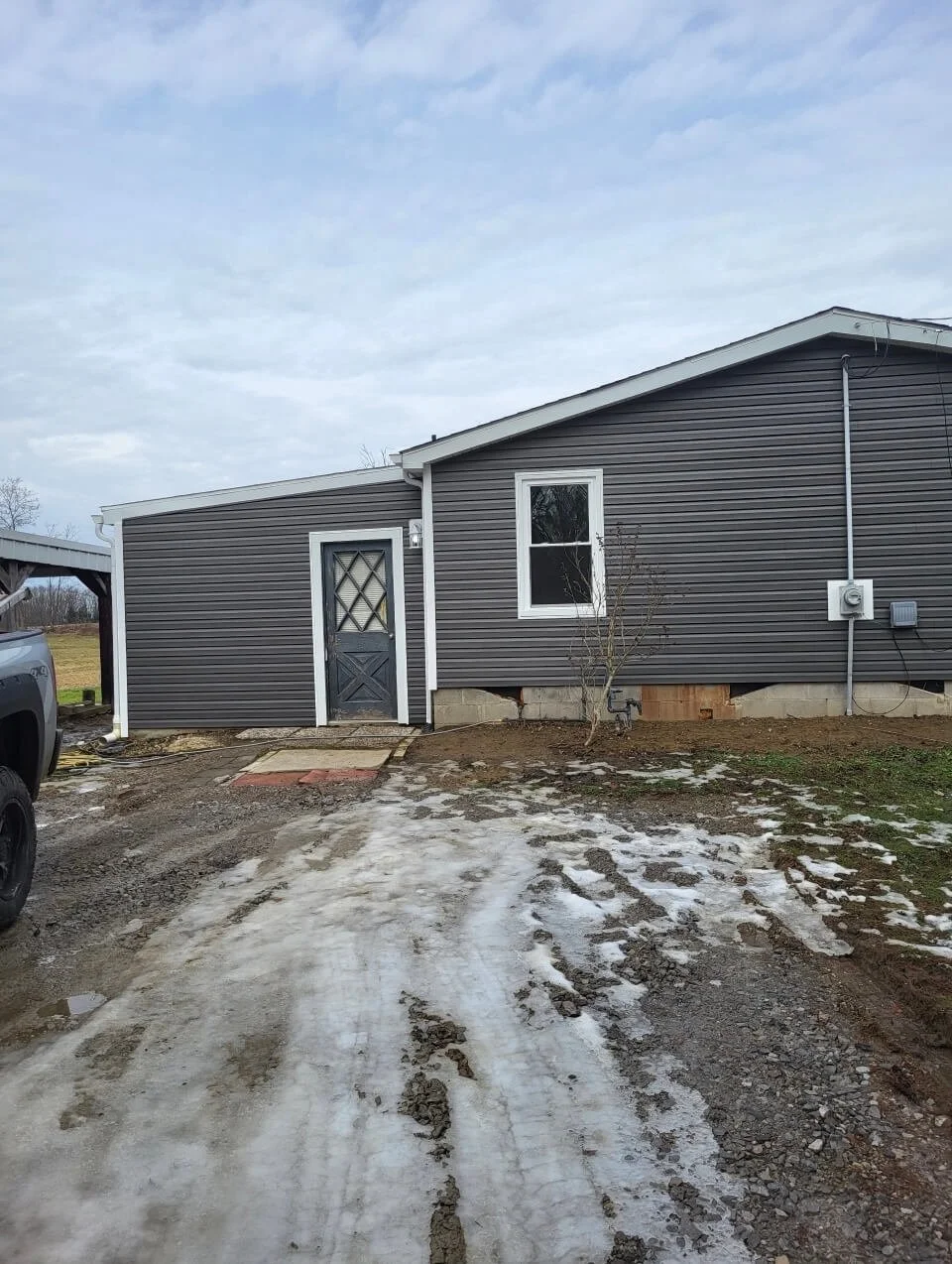 Complete residential home exterior transformation with updated dark gray horizontal siding and a new roof profile in Canton, Ohio.