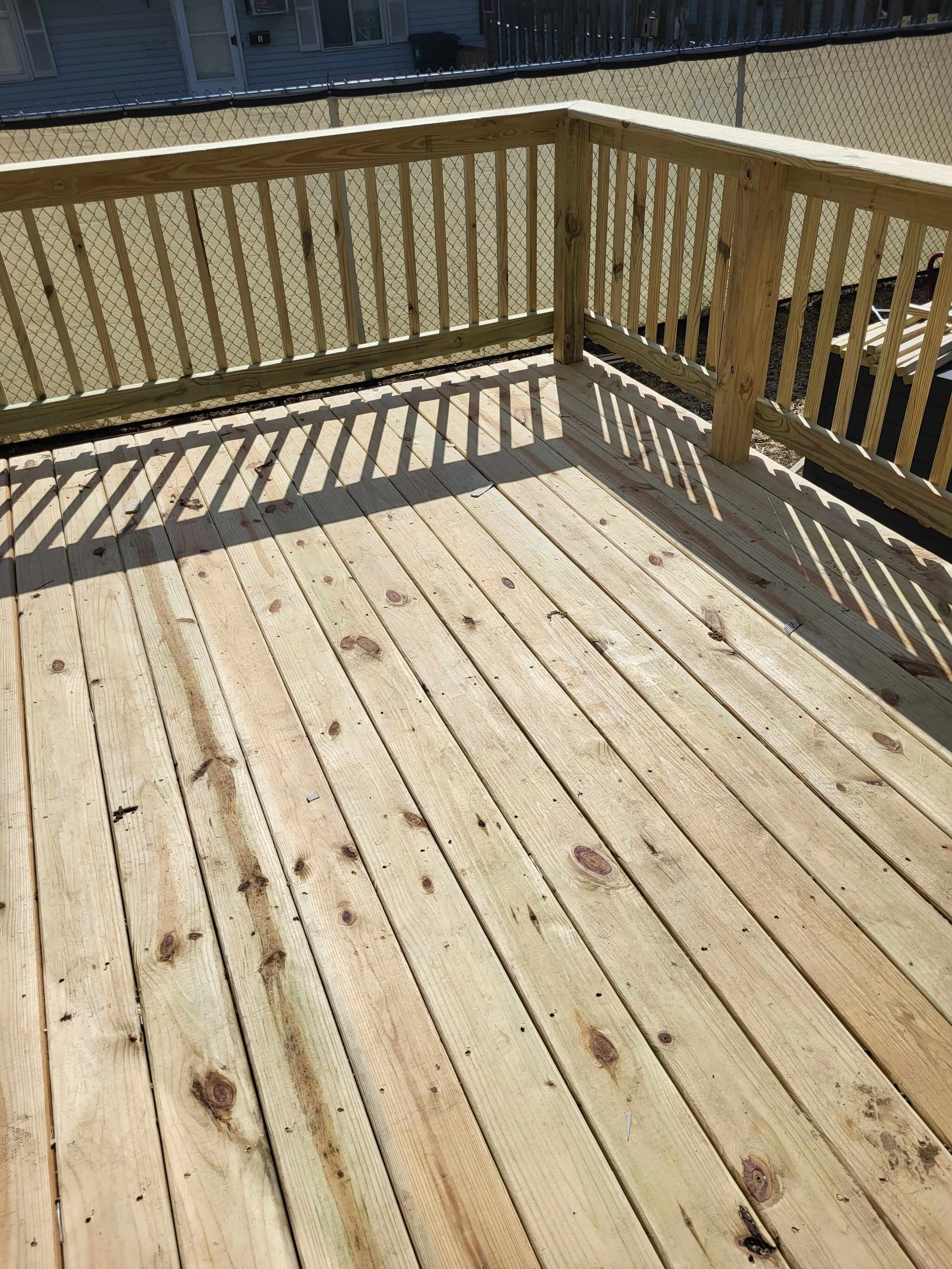 Standing on the newly built deck in Canton, Ohio—highlighting treated wood handrails, secure stairs, and full structural integrity