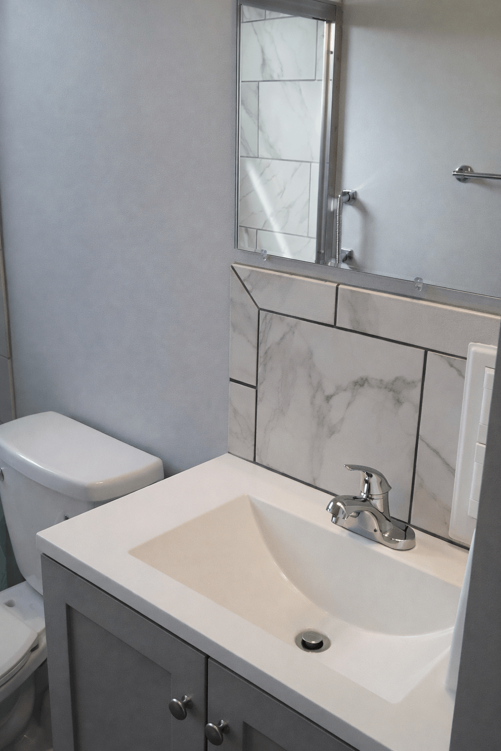 Bathroom vanity installation with tile backsplash during Akron bathroom Renovation.