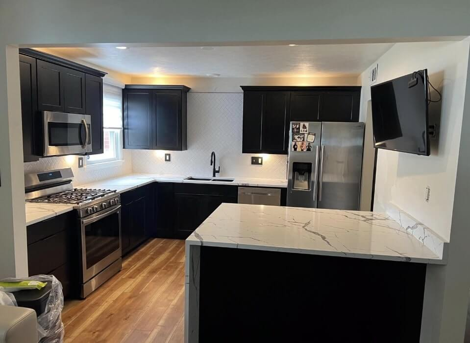 DLR Construction kitchen remodeling project featuring modern dark cabinets quartz countertops and stainless steel appliances