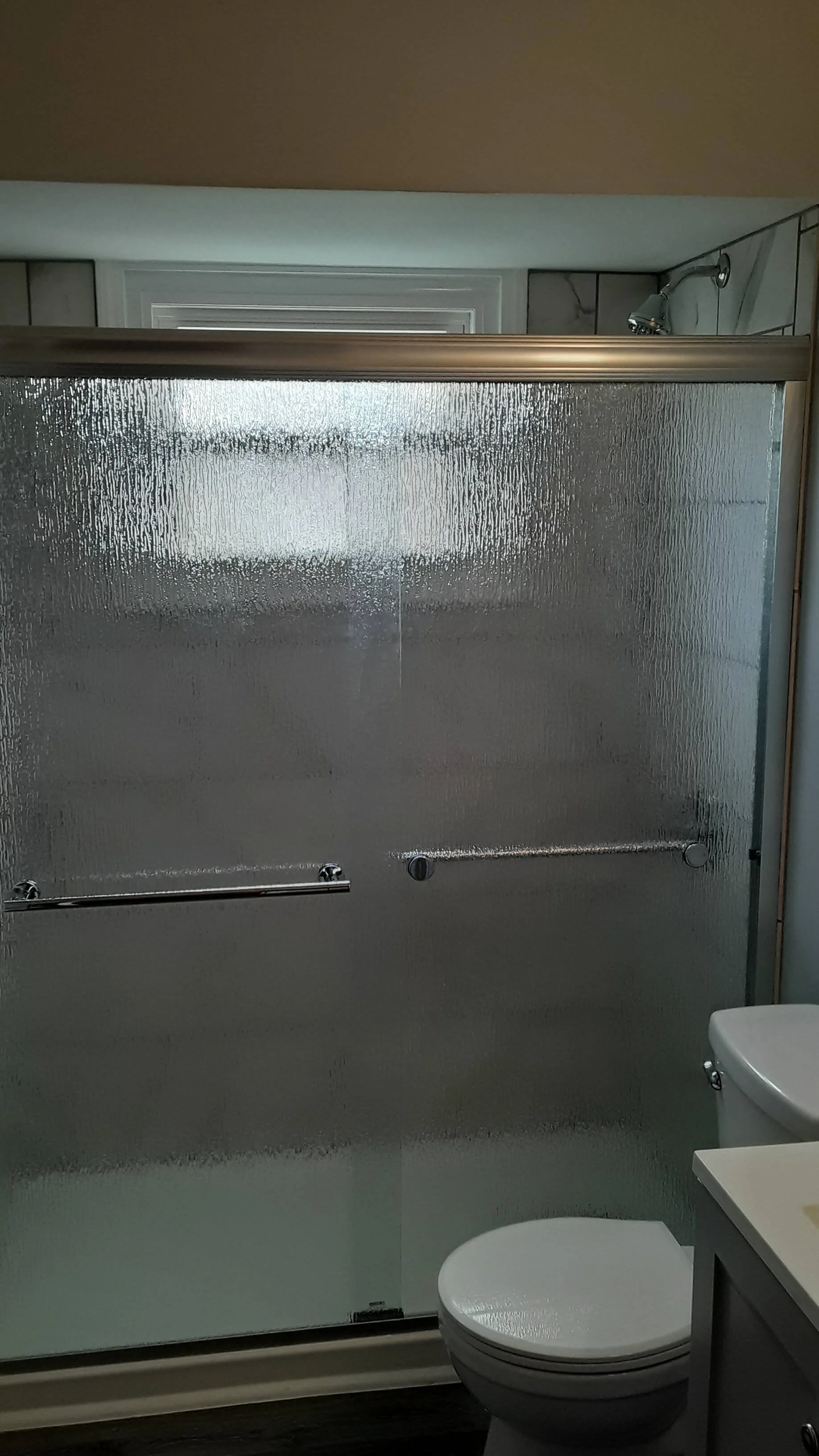 Frosted glass shower doors installed on walk-in tile shower during Akron bathroom Renovation.