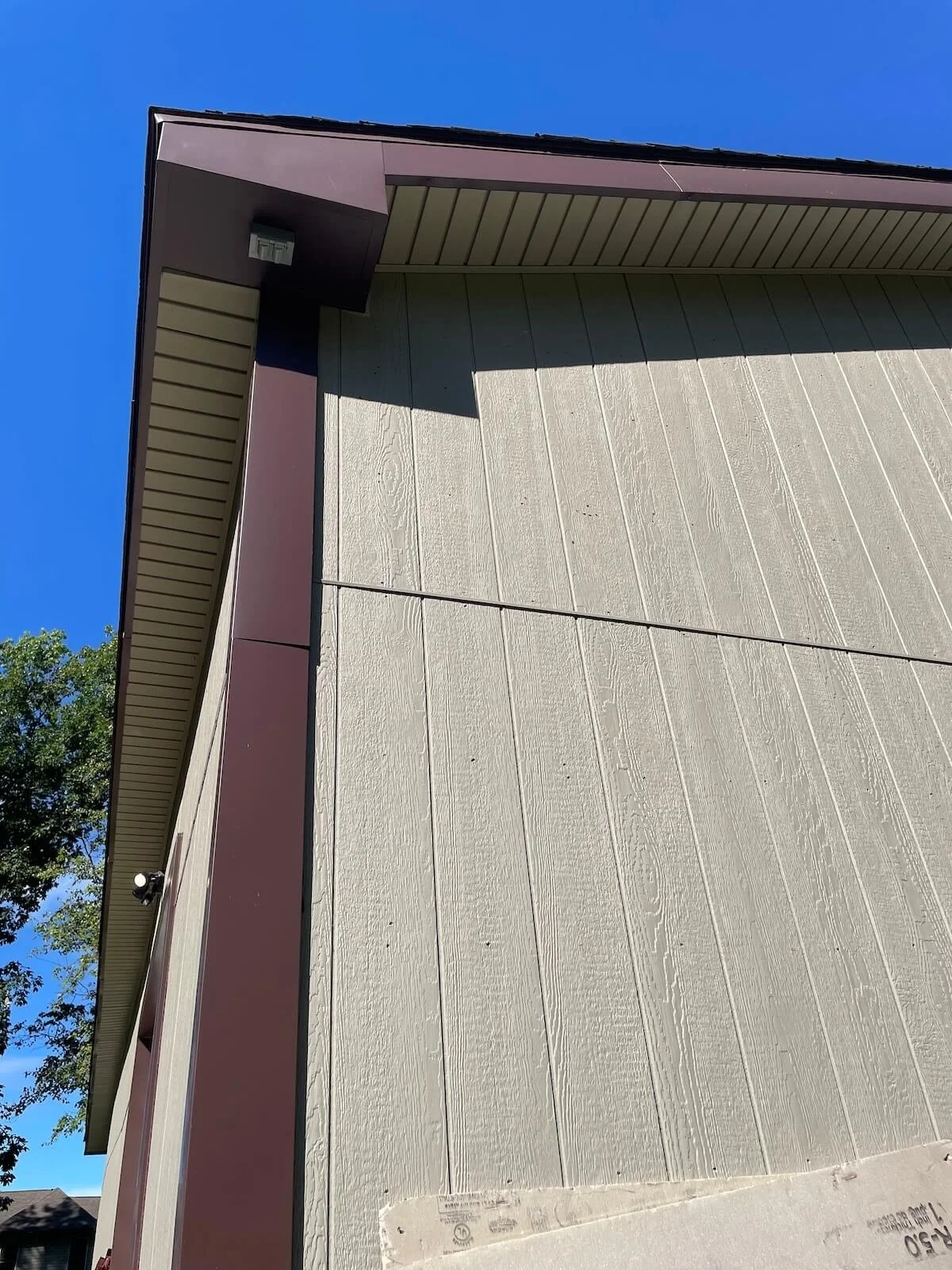 Exterior corner view showcasing the heavy duty T111 siding integration and custom aluminum soffit metalwork on a Stow Ohio workshop addition.