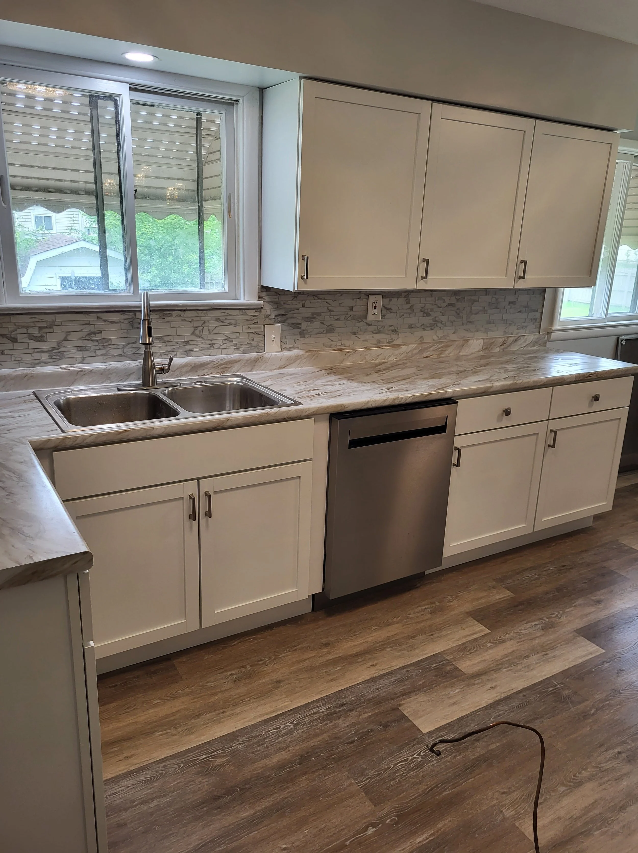 New Kitchen Layout with other half of MDF Laminate Countertop , Dishwasher Installed And Faucet. All Accommodating Plumbing 