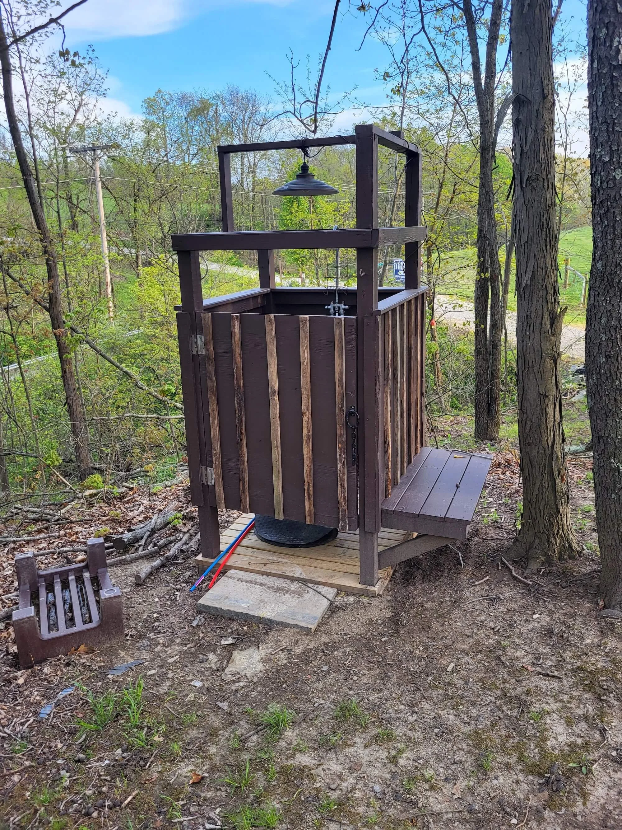 Custom wood outdoor shower structure with warm antique night lighting by DLR Construction in Tallmadge Ohio