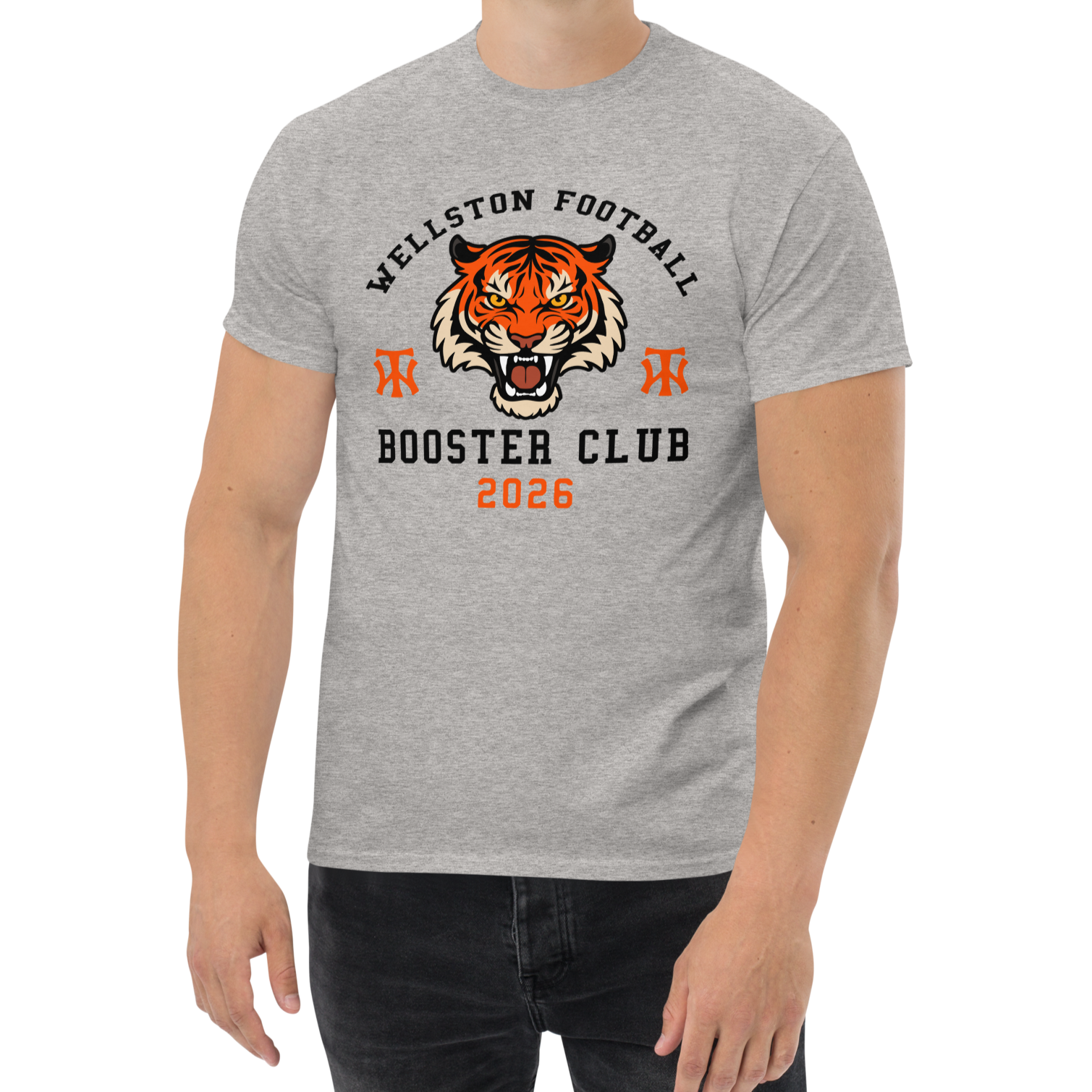 Gray t-shirt with a tiger face graphic, text 'Wellston Football Booster Club 2026', and two orange emblem symbols.
