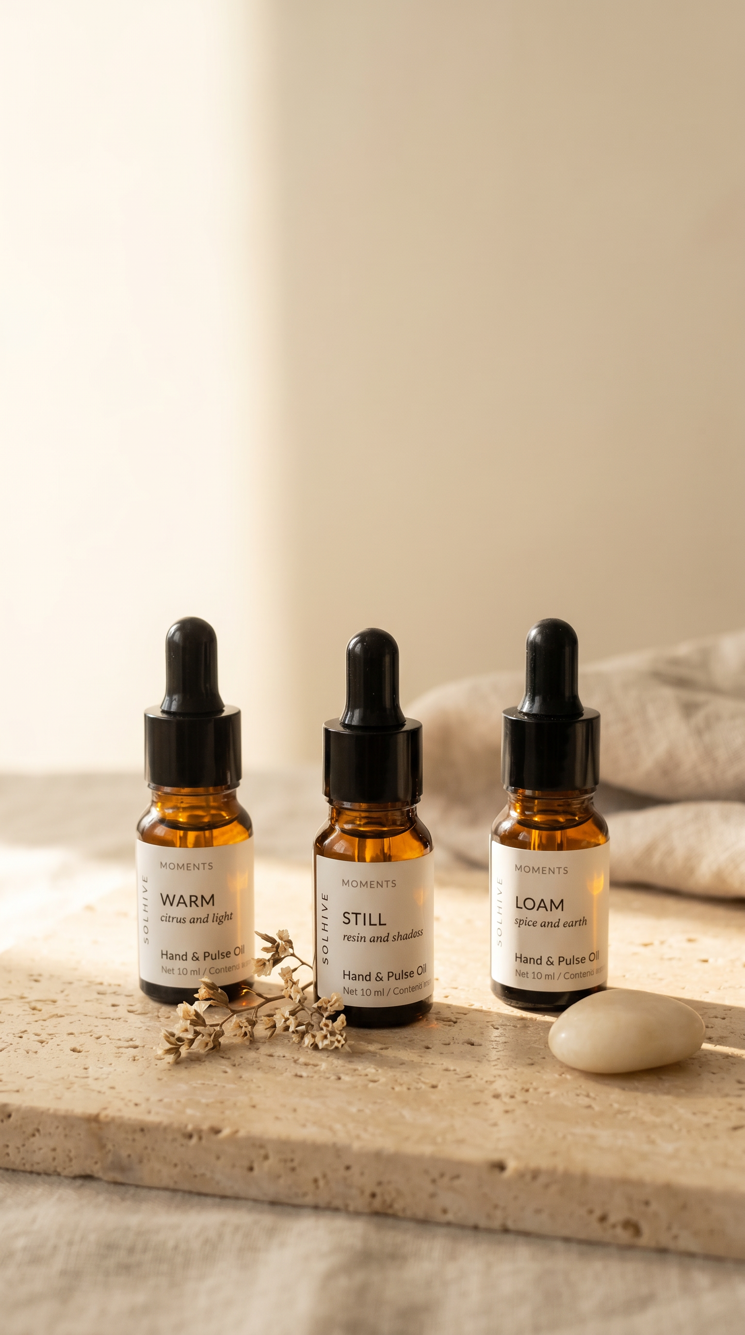Hand Oil Trio on warm travertine stone surface.png