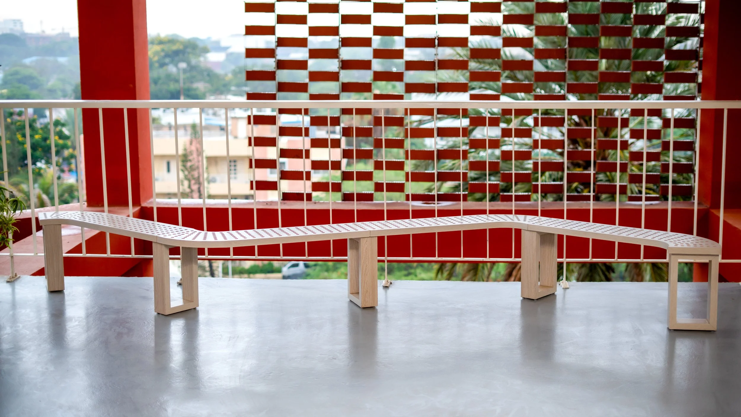 Banc moderne en bois avec assises en grille blanche sur un balcon avec vue sur la ville et végétation sheznou