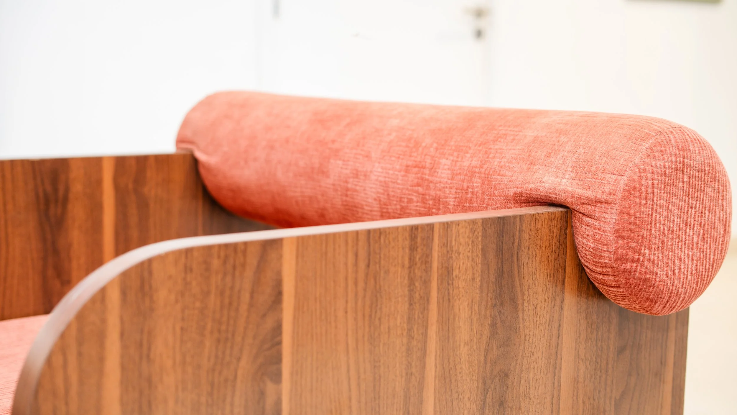 Un bureau en bois avec un coussin rose sur le bord. sheznou