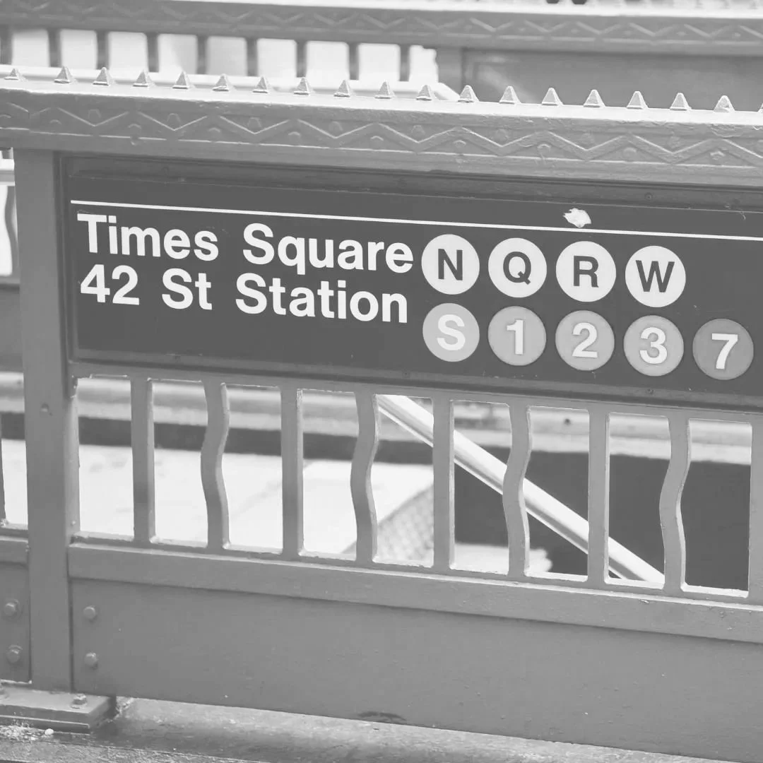 Subway station sign for Times Square 42 Street Station with train line icons for N, Q, R, W, S, 1, 2, 3, and 7.