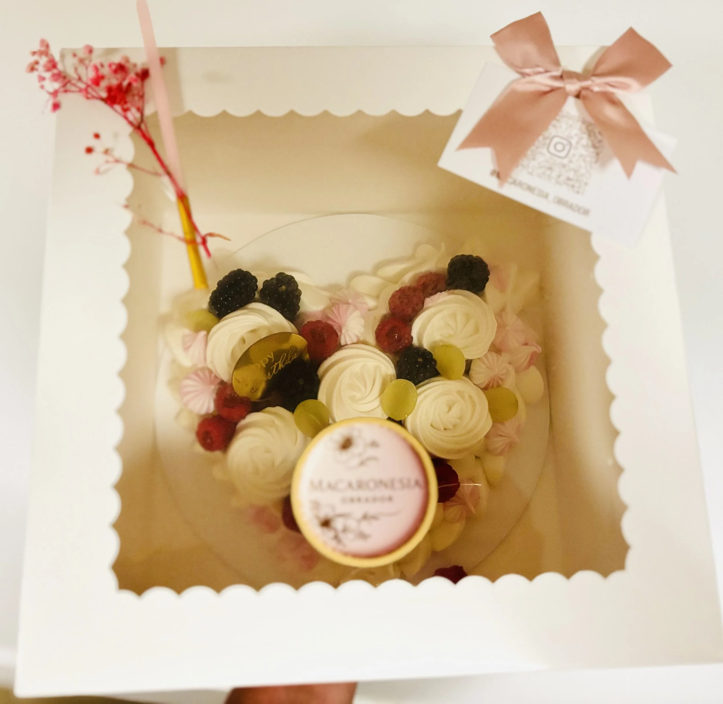 Pastel de cumplea f1os decorado con frutos rojos y crema, en una caja blanca con ventana de vidrio