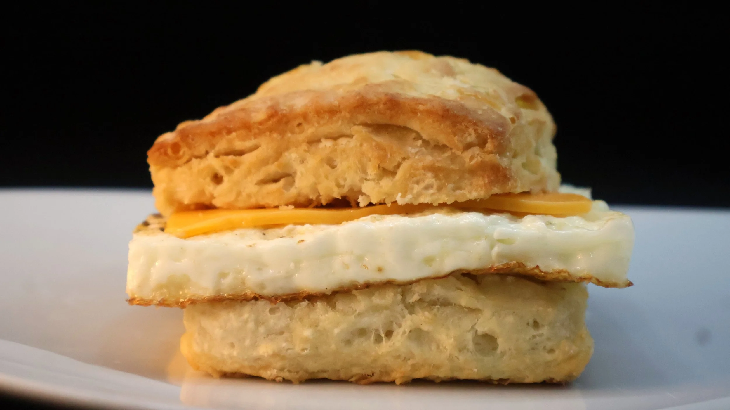Two fried eggs with a slice of american cheese centered in a biscuit