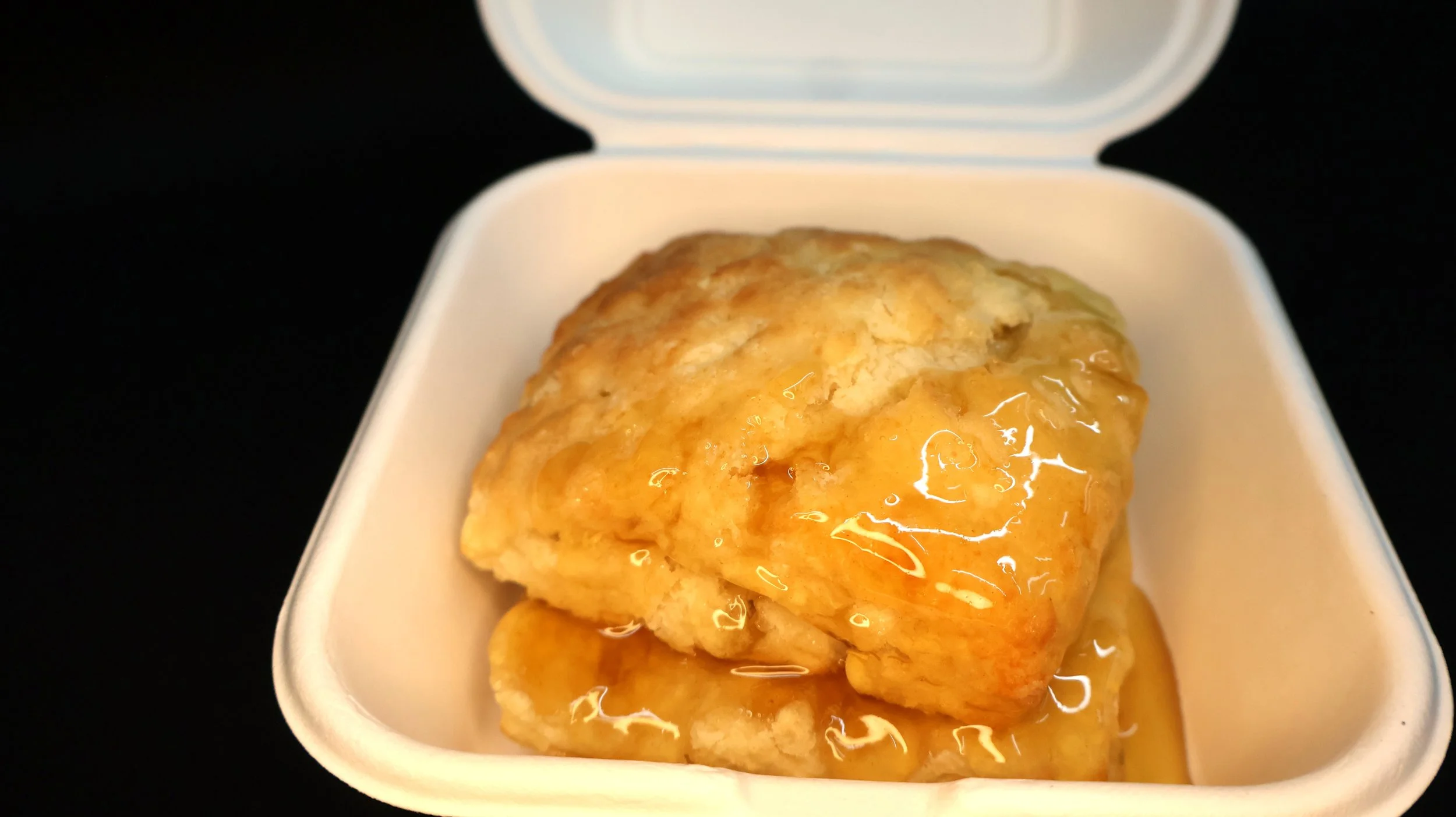 A split biscuit smothered in honey