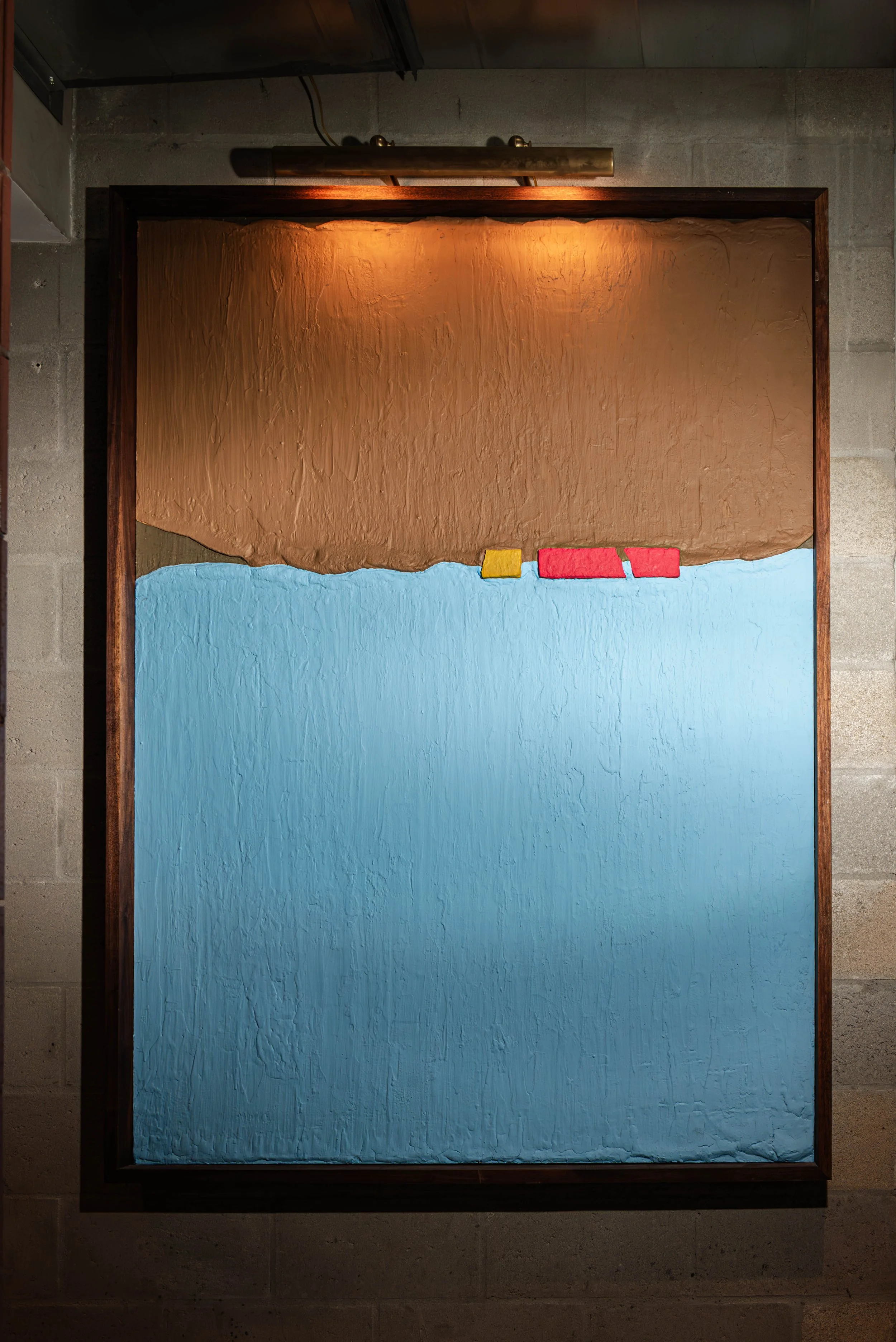 Abstract textured painting divided into two sections, with the top section in brown and the bottom in blue. Small yellow and red rectangular shapes are near the boundary between the sections.