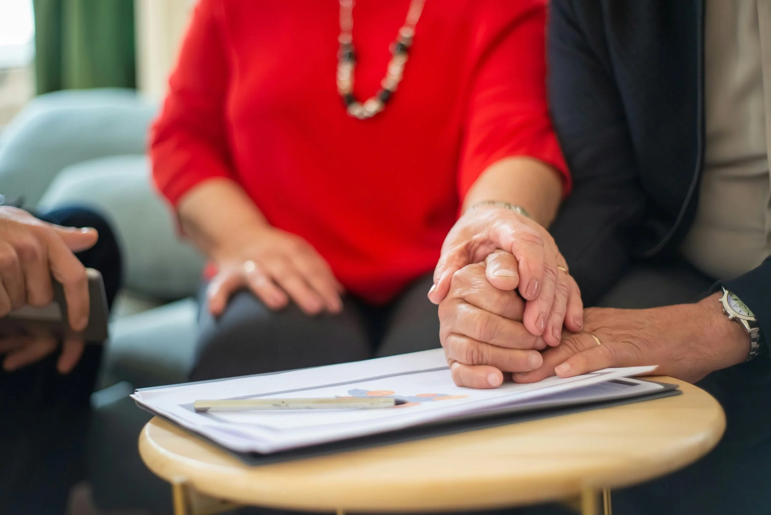 a couple holding hands which are on top of paperwork