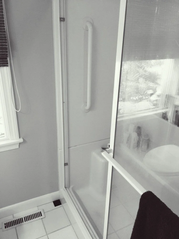 Bathroom remodel featuring a walk-in shower with sliding door and tile walls by At Design Remodel in Mashpee.jpg