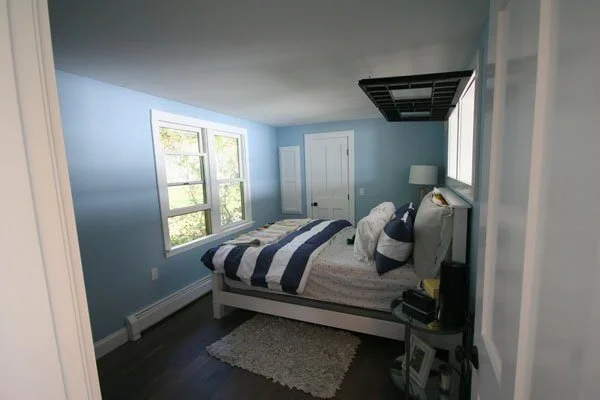 Freshly remodeled bedroom featuring blue walls and large windows in a Mashpee custom home.jpg