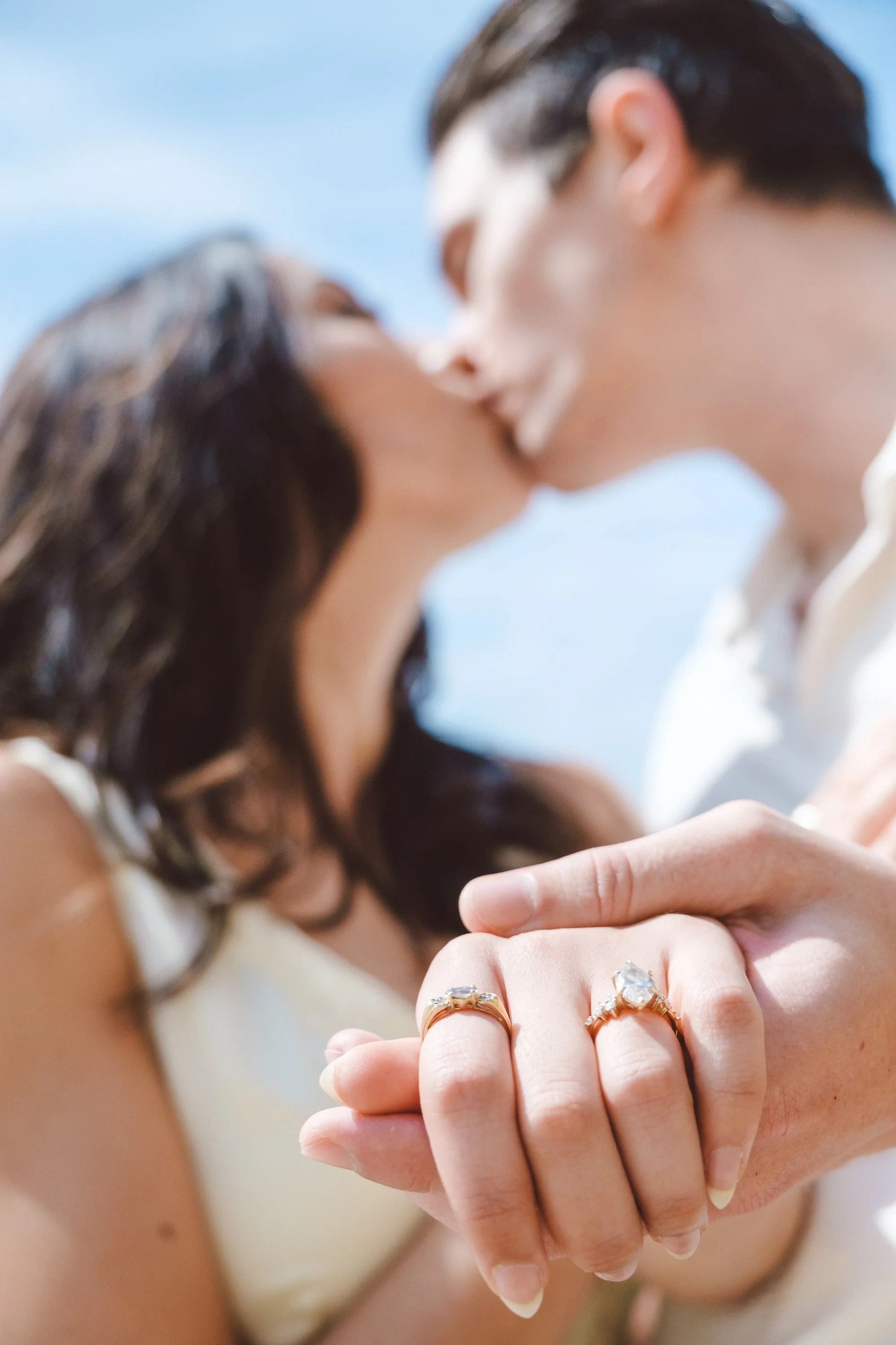 Close up of hands with engagement rings as the couple shares a quiet moment in Laguna Beach.