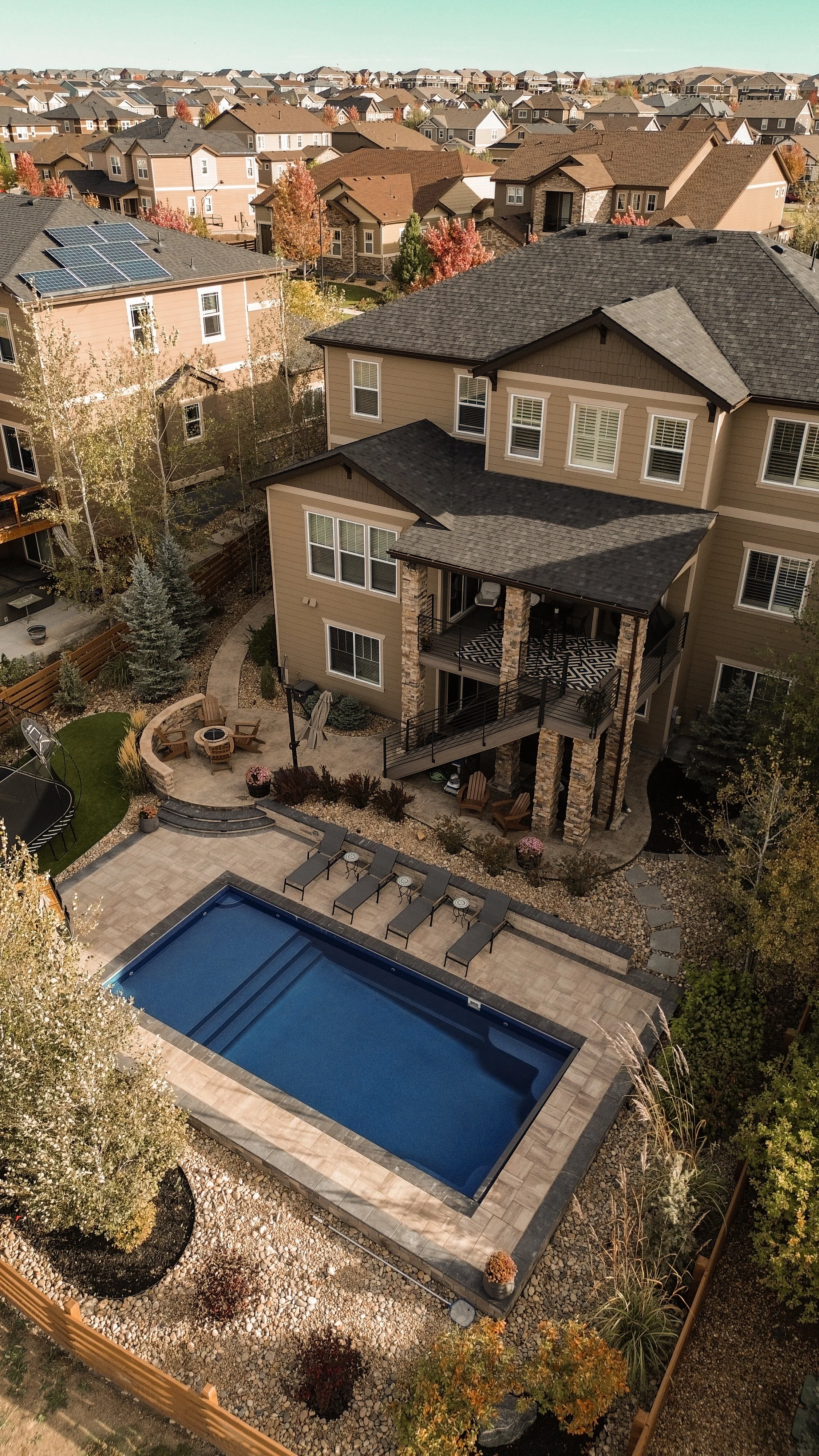 Fiberglass pool in Erie Colorado from above with paver patio and fire pit