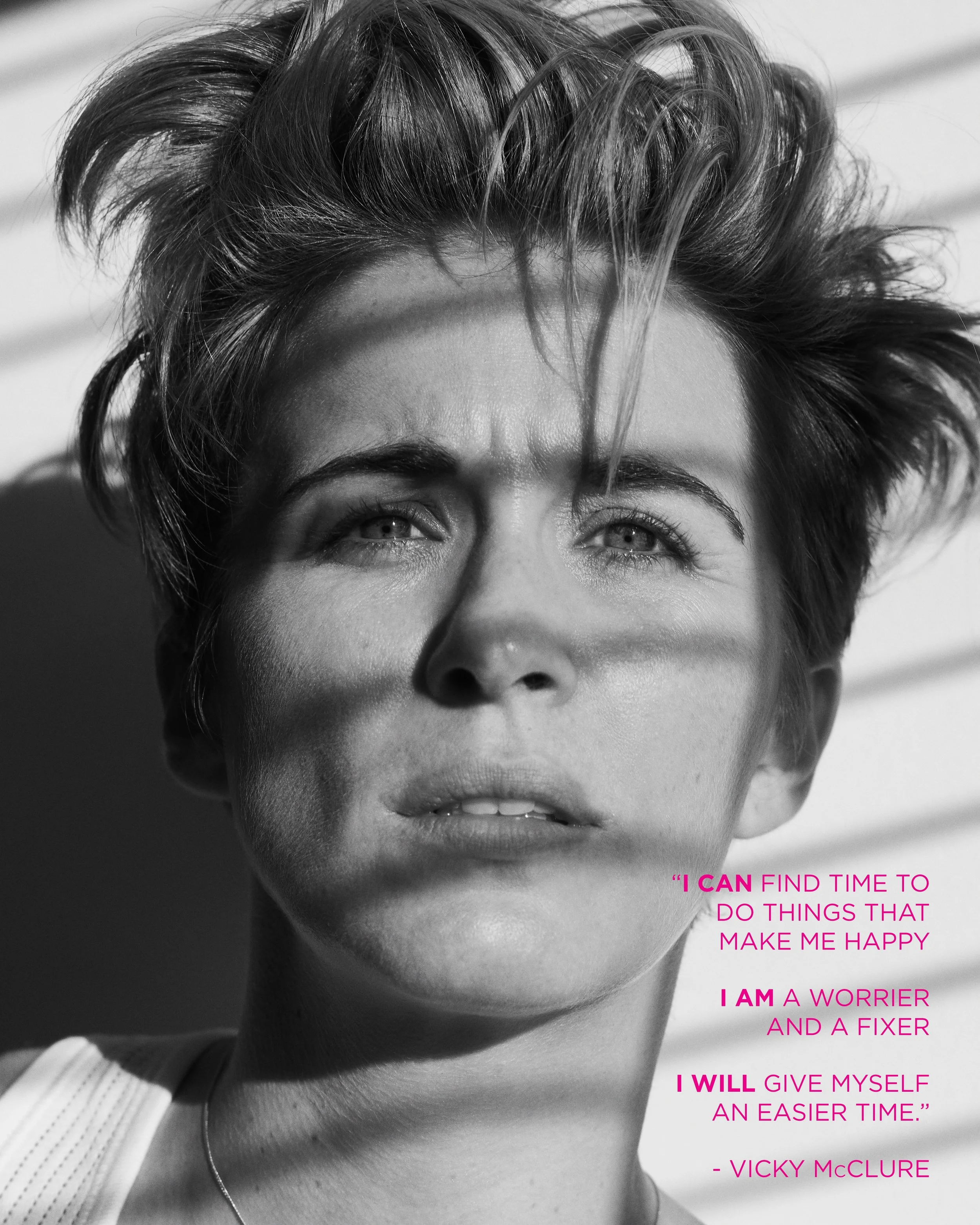Black and white close-up portrait of a woman with short, tousled hair, looking slightly up, with shadow stripes on her face and a quote in pink text on the lower right.