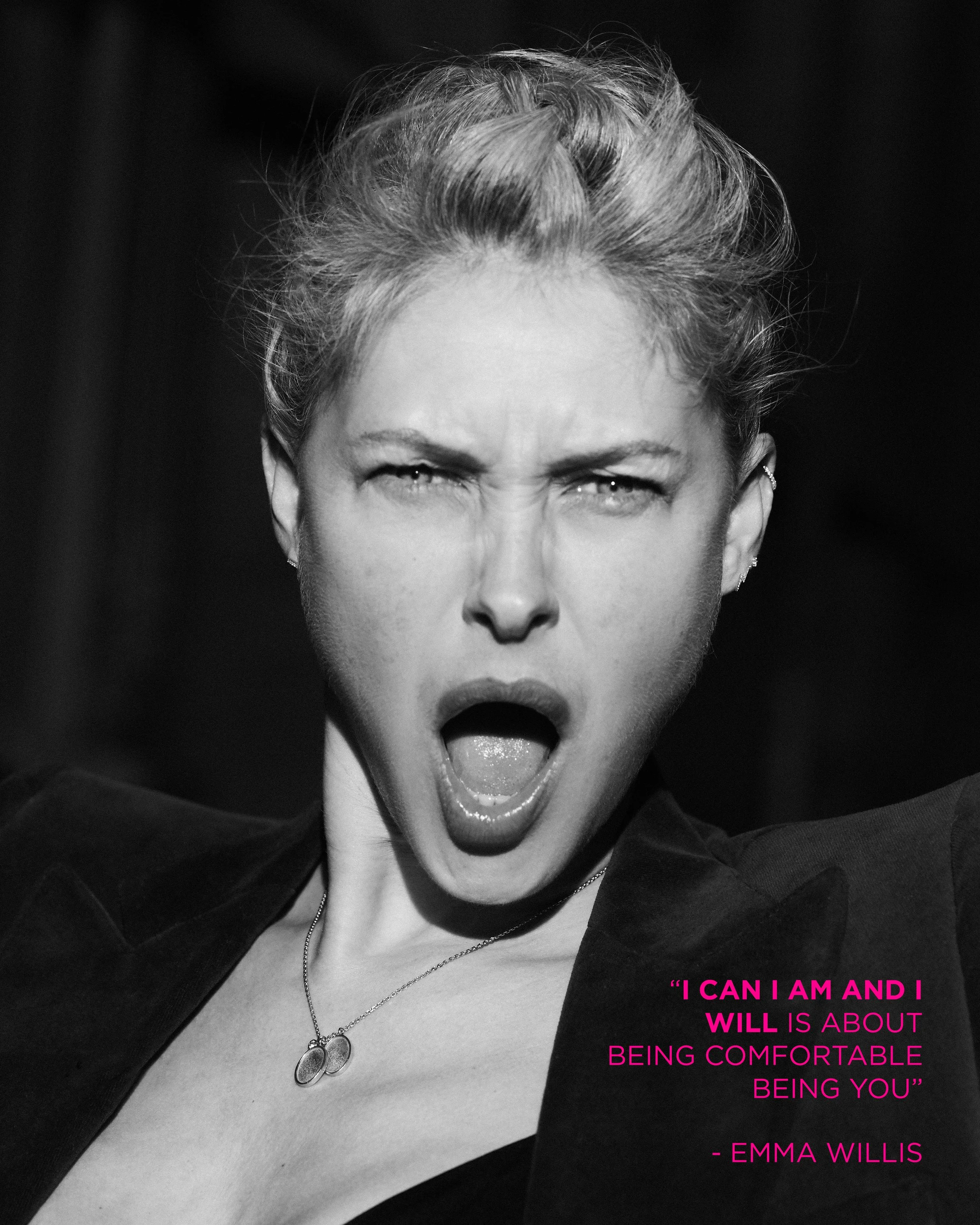 Black and white photo of a woman with short hair, mouth open as if yelling or singing, wearing a necklace and earrings. Pink quote text at bottom right saying, "I CAN I AM AND I WILL IS ABOUT BEING COMFORTABLE BEING YOU" - EMMA WILLIS.