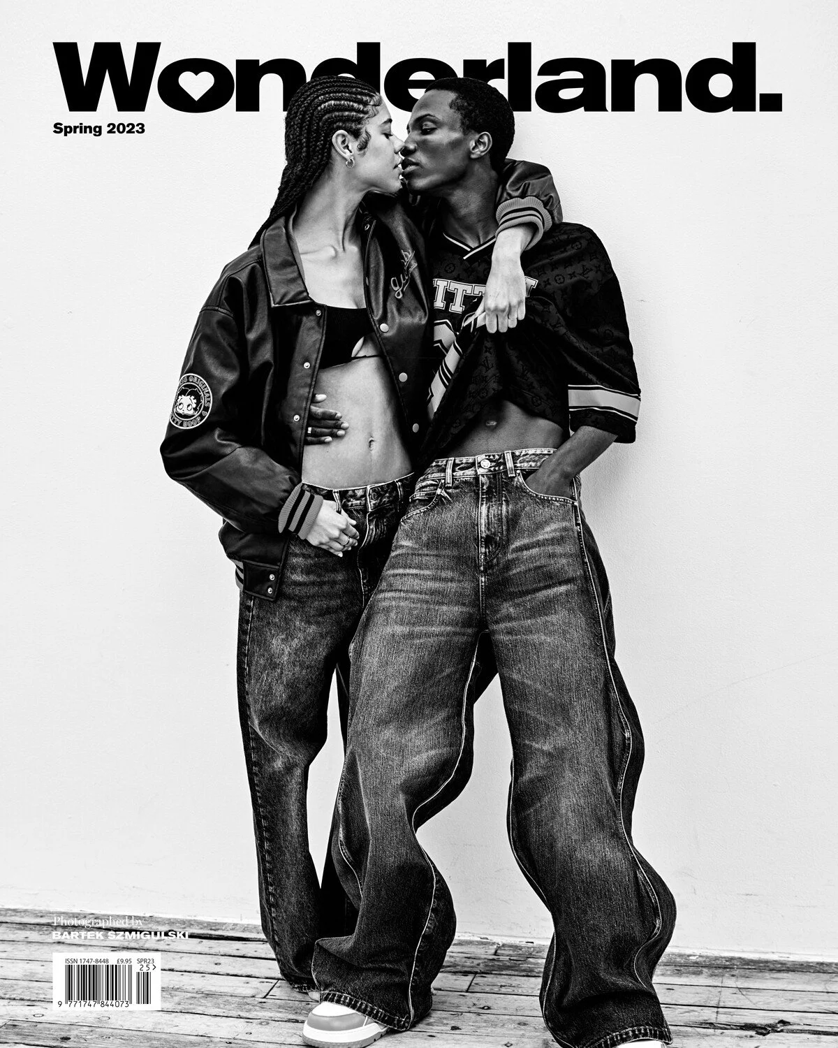 Black and white magazine cover titled 'Wonderland' Spring 2023 featuring two models in casual streetwear, leaning close, and touching.