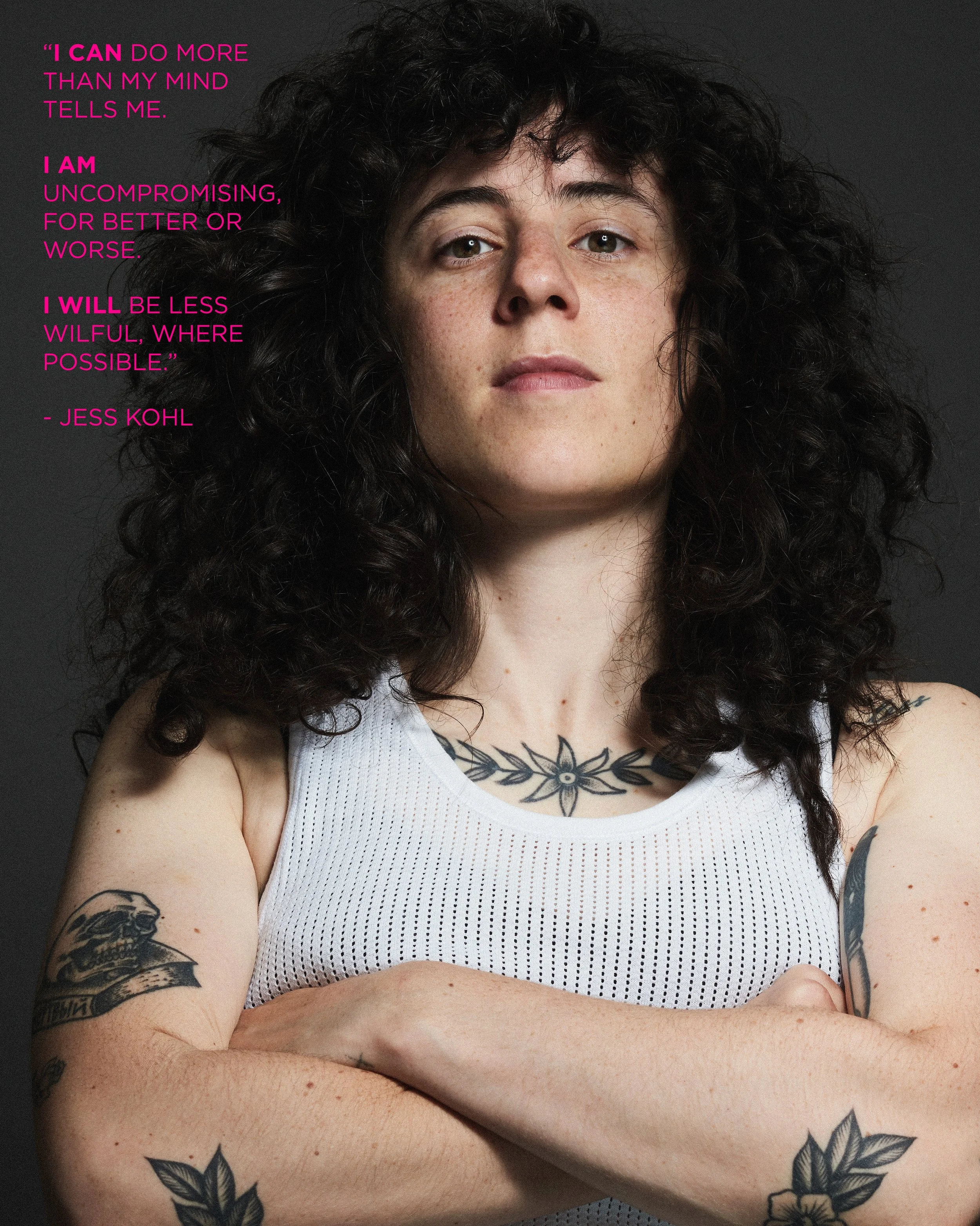 Portrait of a woman with curly dark hair, tattoos on her arms and chest, wearing a white sleeveless top, with a quote from Jess Kohl in pink text on the left side of the image.