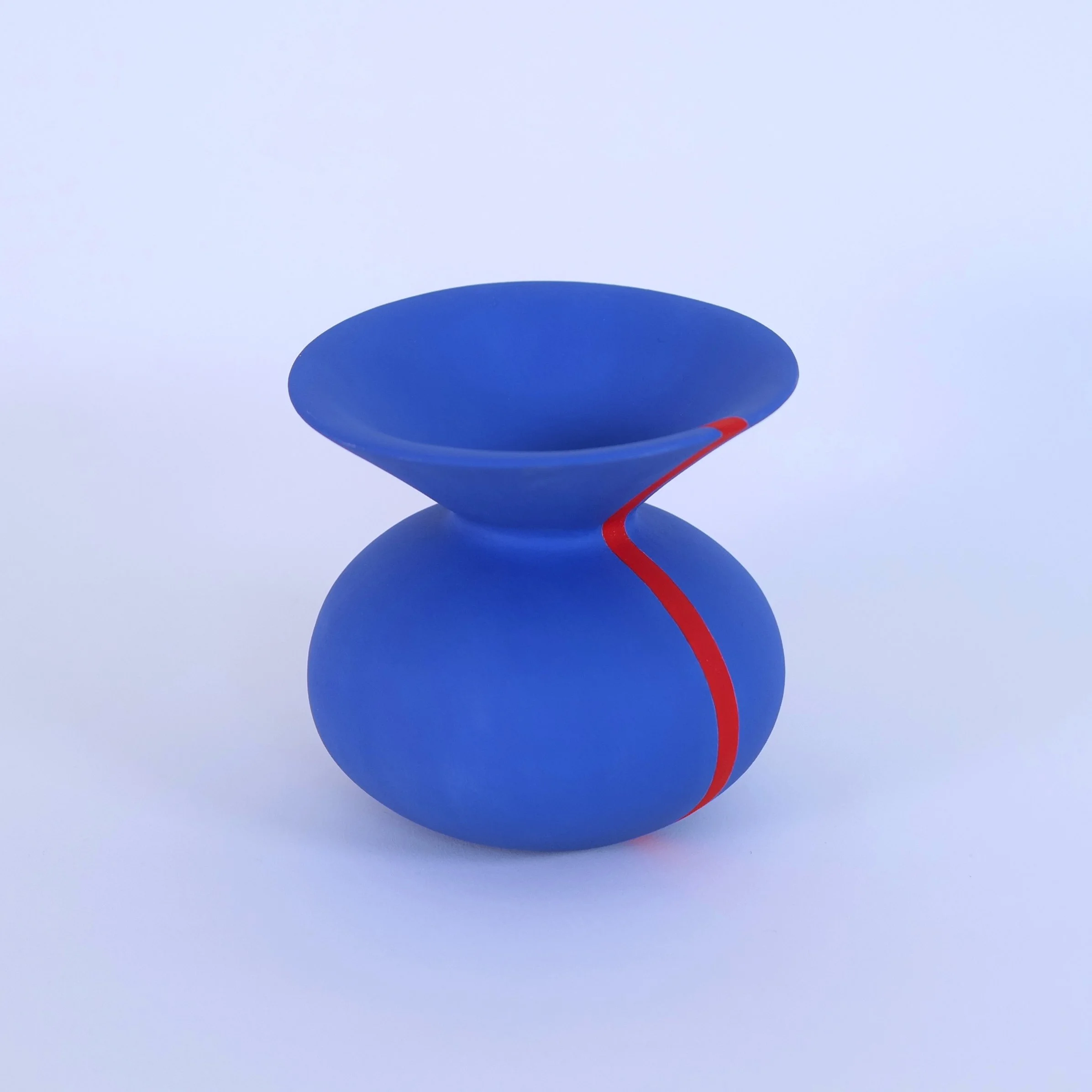 Modern blue ceramic vase with an exaggerated flared open top and a red accent line running down one portion of the vessel.