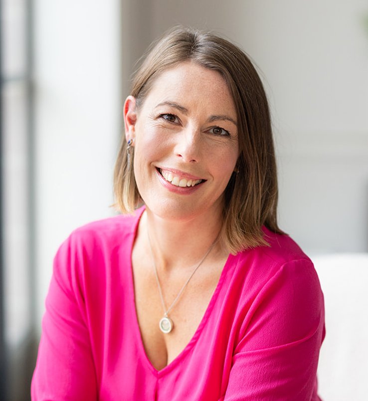 Jo Lovemore, nutritional therapist, with shoulder-length brown hair wearing a pink top.